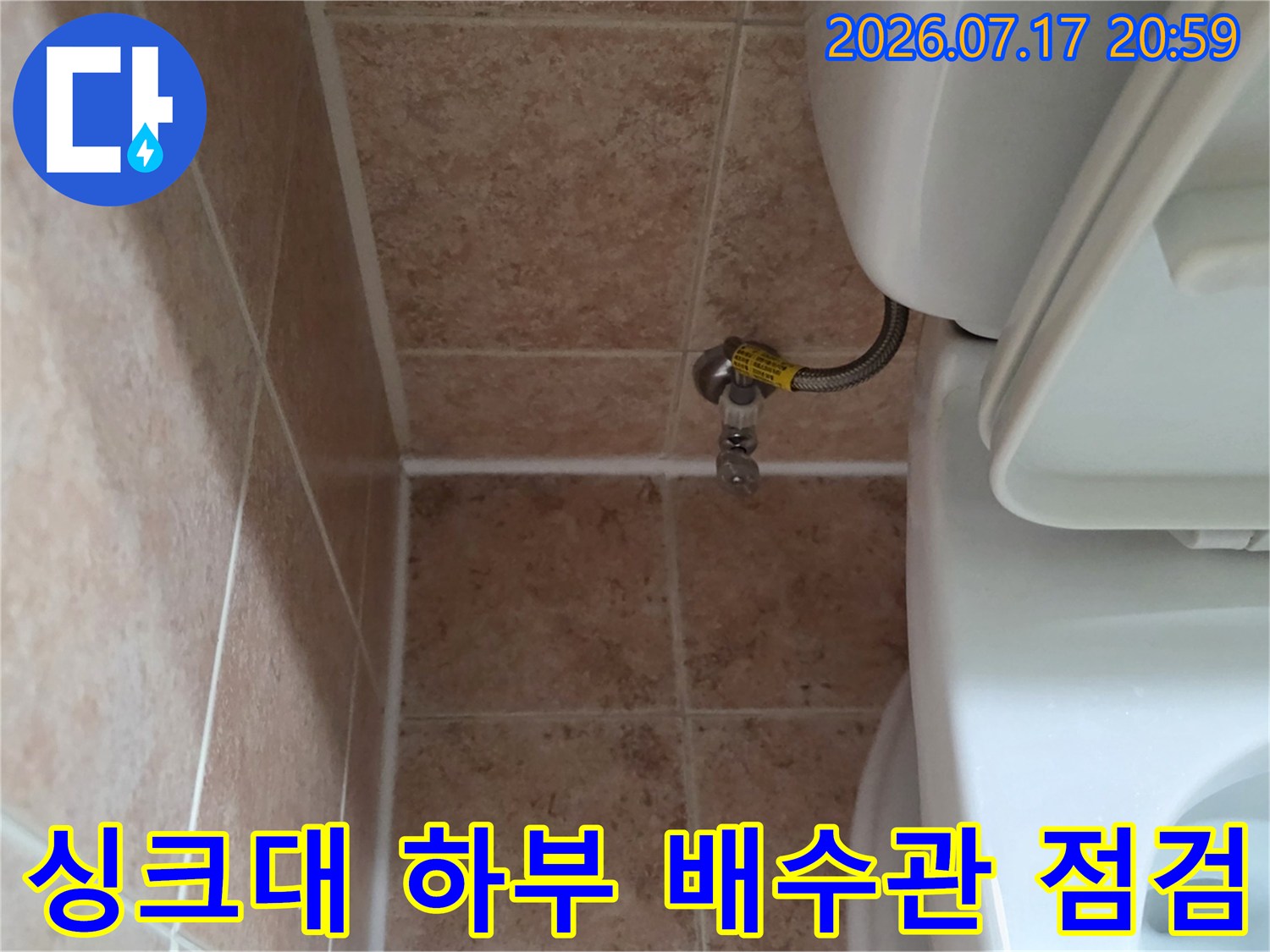 싱크대 아래쪽으로 연결된 노출 배수관과 밸브 부위를 상세히 촬영한 모습