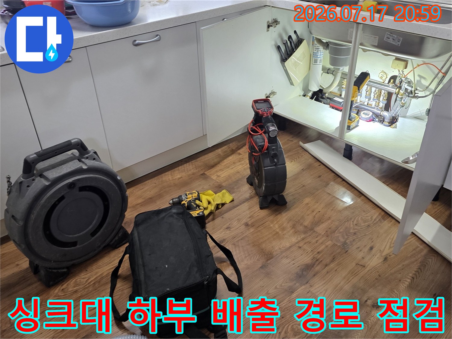 전문적인 장비를 사용하여 싱크대 아래쪽 배관망을 면밀히 분석하는 모습