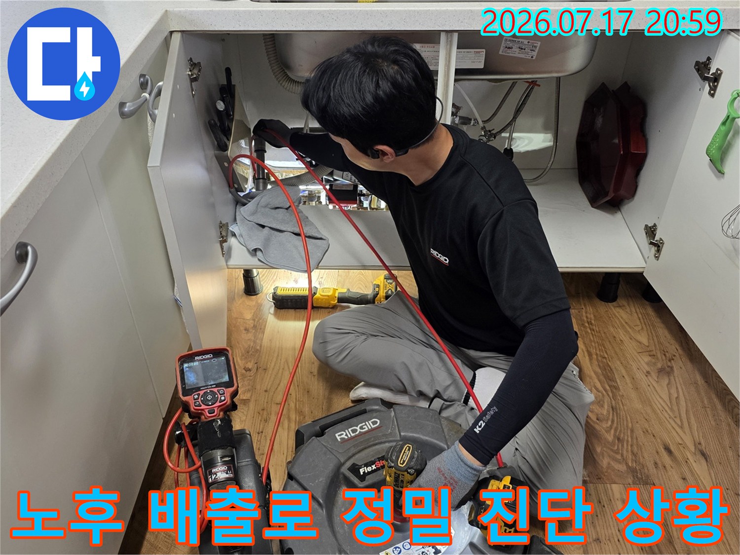 전문적인 장비를 사용하여 싱크대 하부의 노후된 배출 경로를 면밀히 조사하는 과정