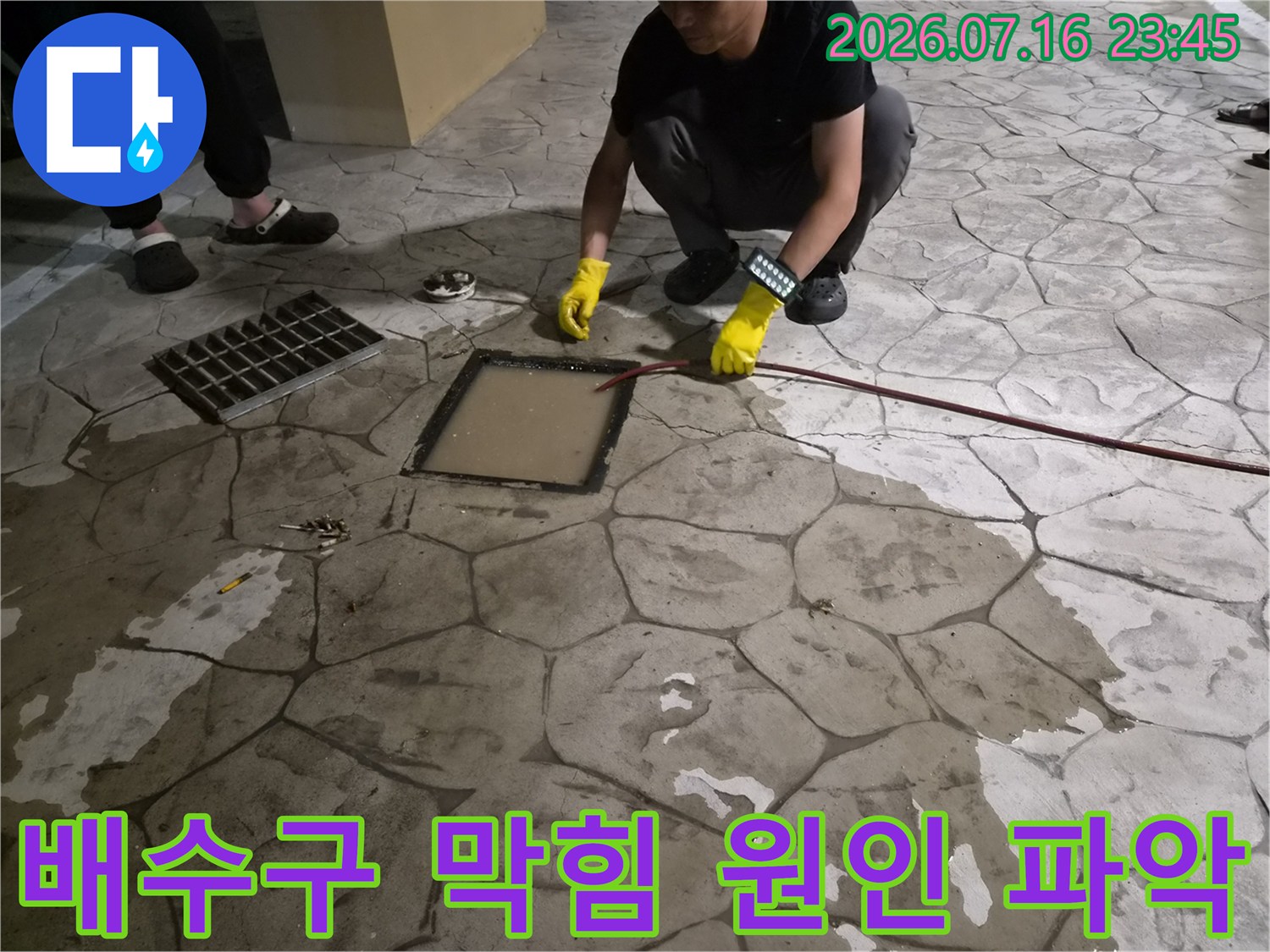 노란 장갑을 낀 전문가가 내시경 장비를 조작하며 배관 상태를 확인하는 모습