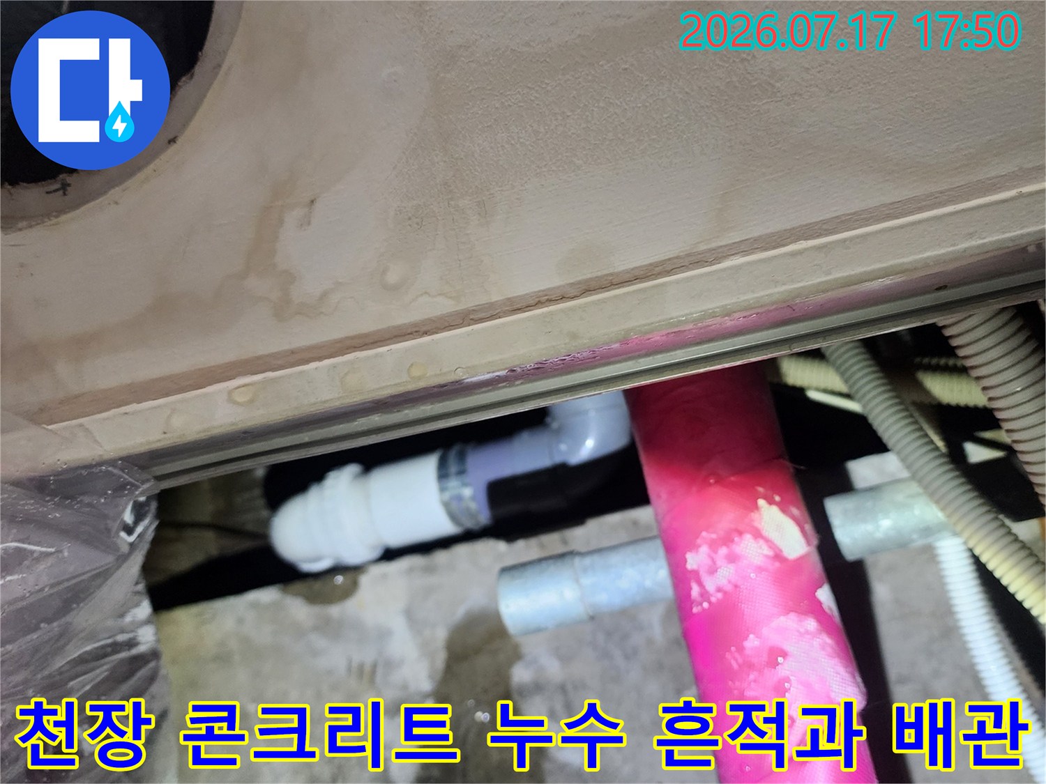 분홍색-보온재-배관-아래로-물에-젖어-얼룩진-콘크리트-천장-모습