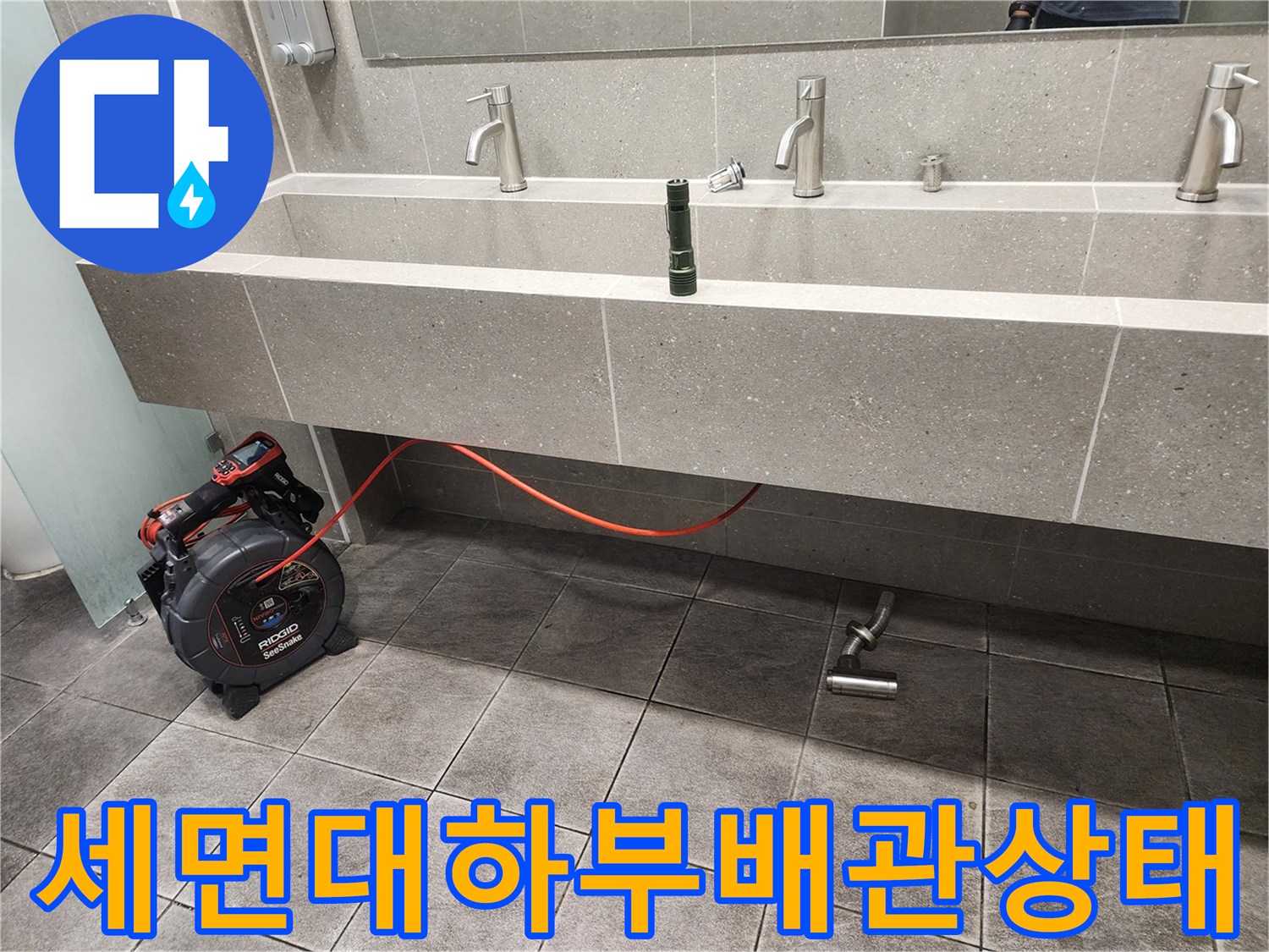 신촌 화장실 세면대 아래쪽 배수 트랩과 점검 장비 모습