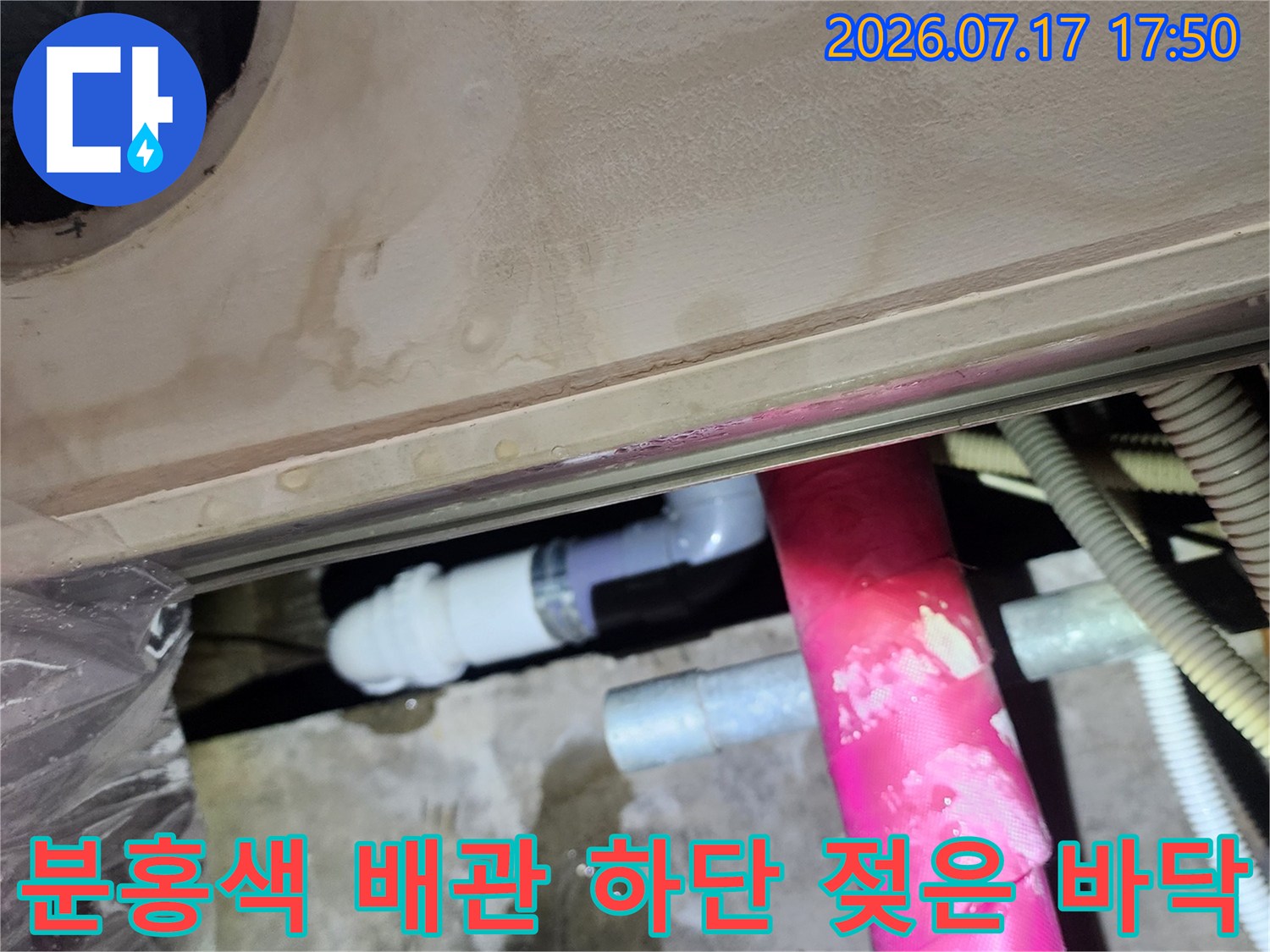 천장 내부의 분홍색 보온재 처리된 배관 아래로 물 얼룩이 넓게 퍼진 모습