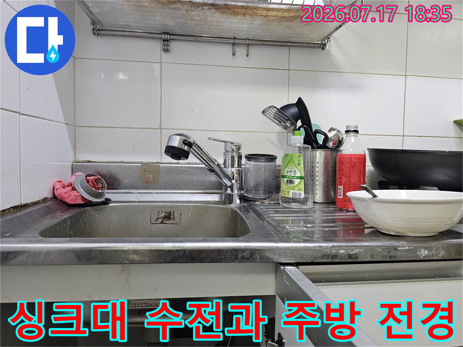 주방 싱크대 상판 위에 설치된 은색 수전-세제와 그릇이 놓여있는 모습
