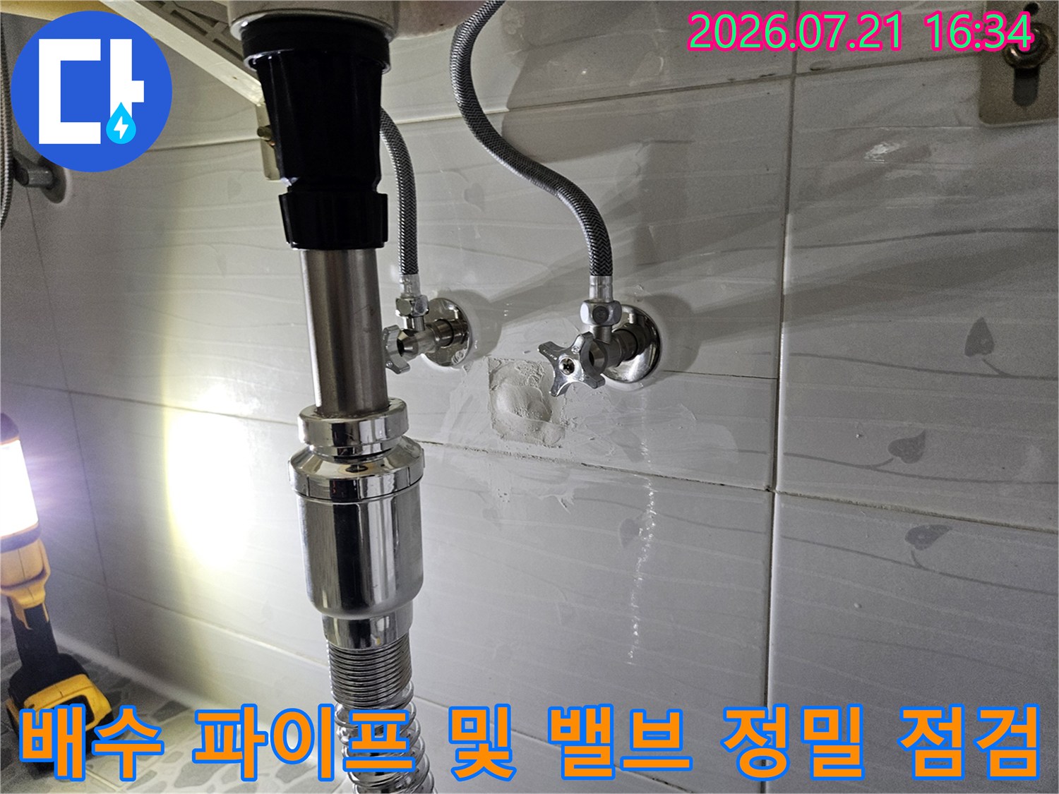 화장실 내부 배수 시스템과 수도 연결부를 점검하여 누수를 예방하는 모습