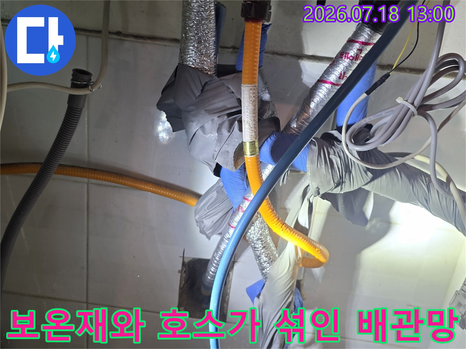 은색 보온재로 감싸진 배관과 파란색 수도관이 복잡하게 연결된 모습-상세컷