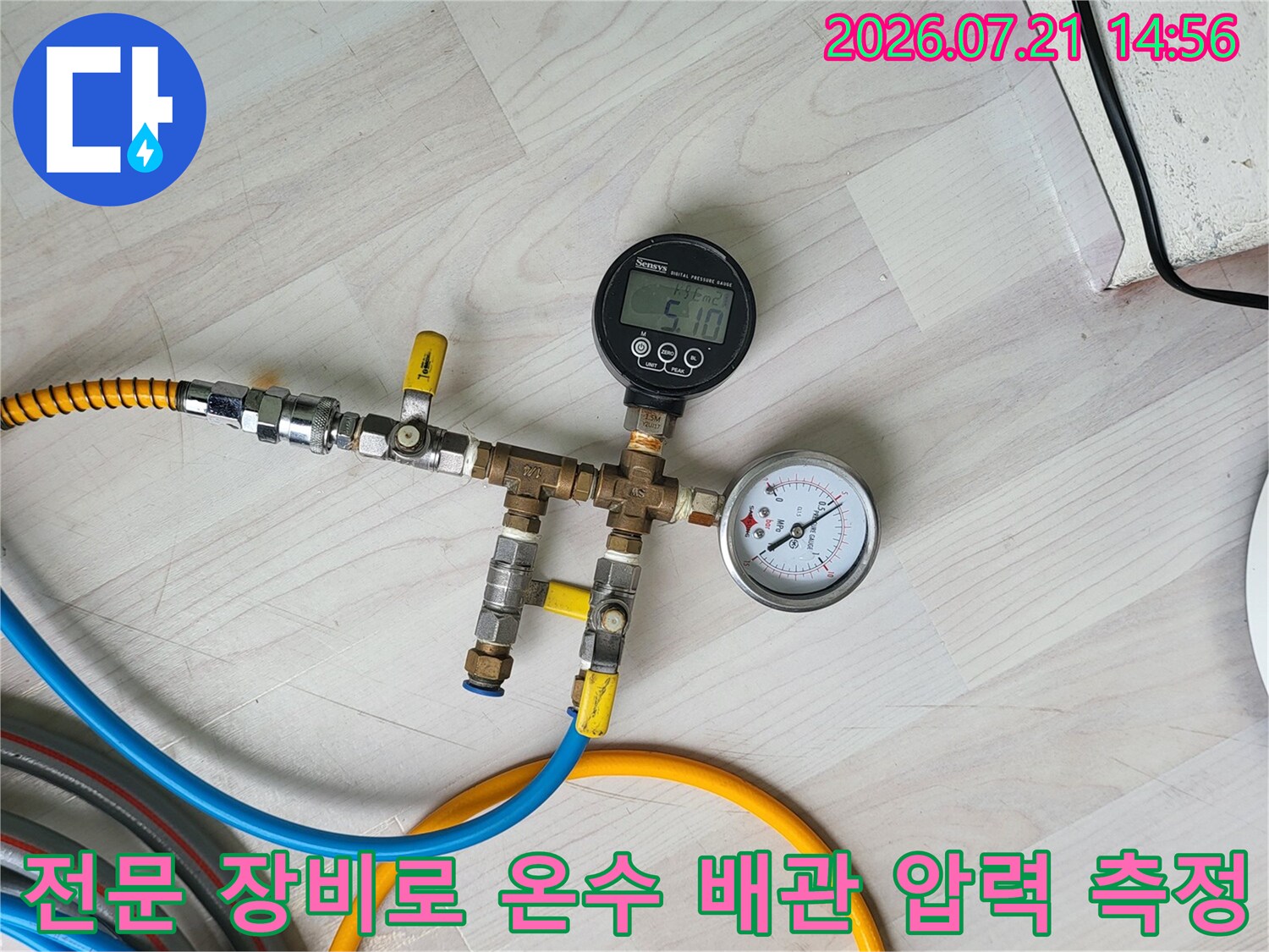 온수 배관에 연결된 측정용 호스와 게이지를 통해 압력을 체크하는 모습