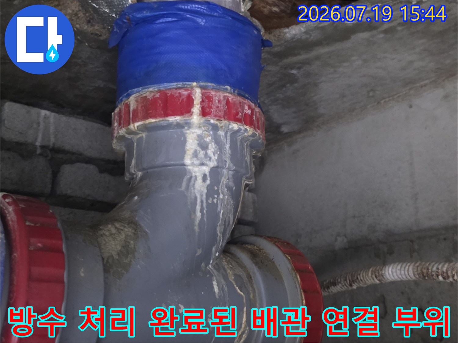 콘크리트 천장 구조물 사이로 설치된 파란색 테이핑 배관