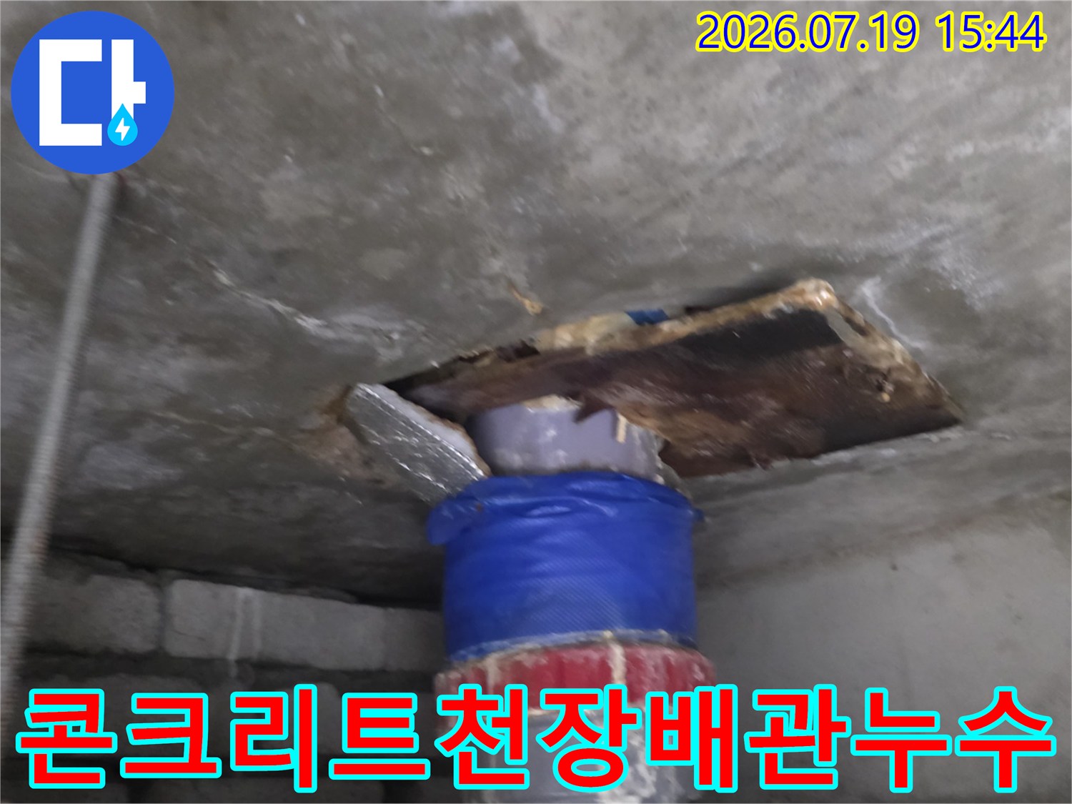 파란색-보온재가-감싸진-하수-배관과-주변의-젖은-콘크리트-슬래브-표면