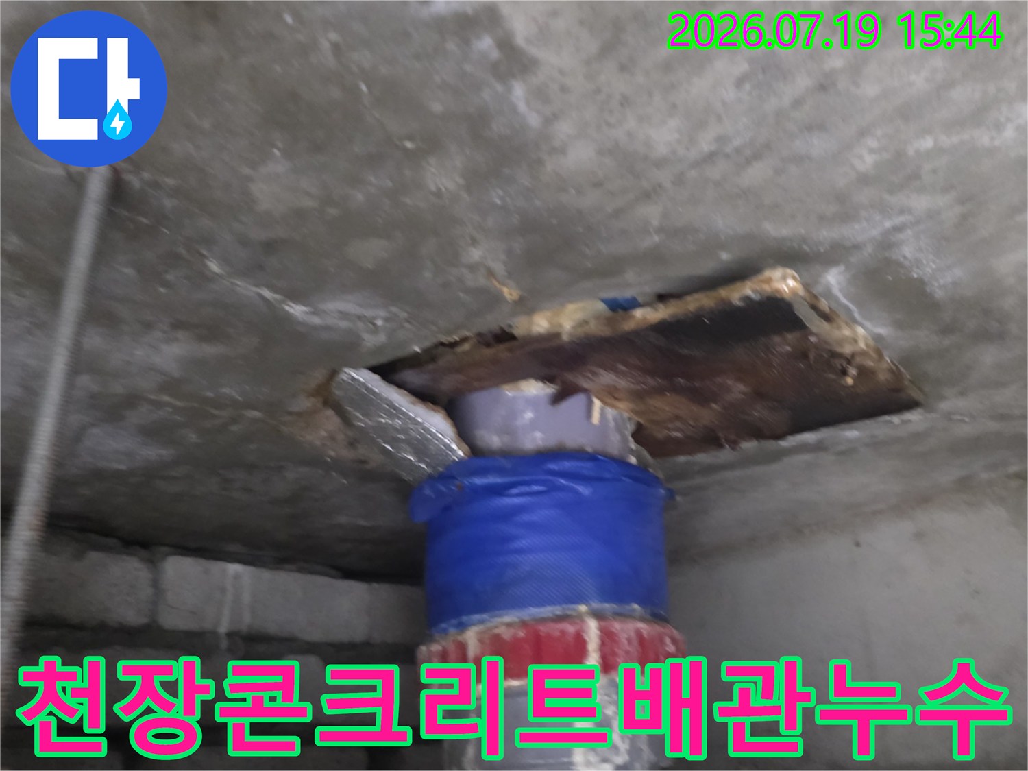 파란색-보온재가-씌워진-하수-배관과-주변의-젖어있는-콘크리트-슬래브