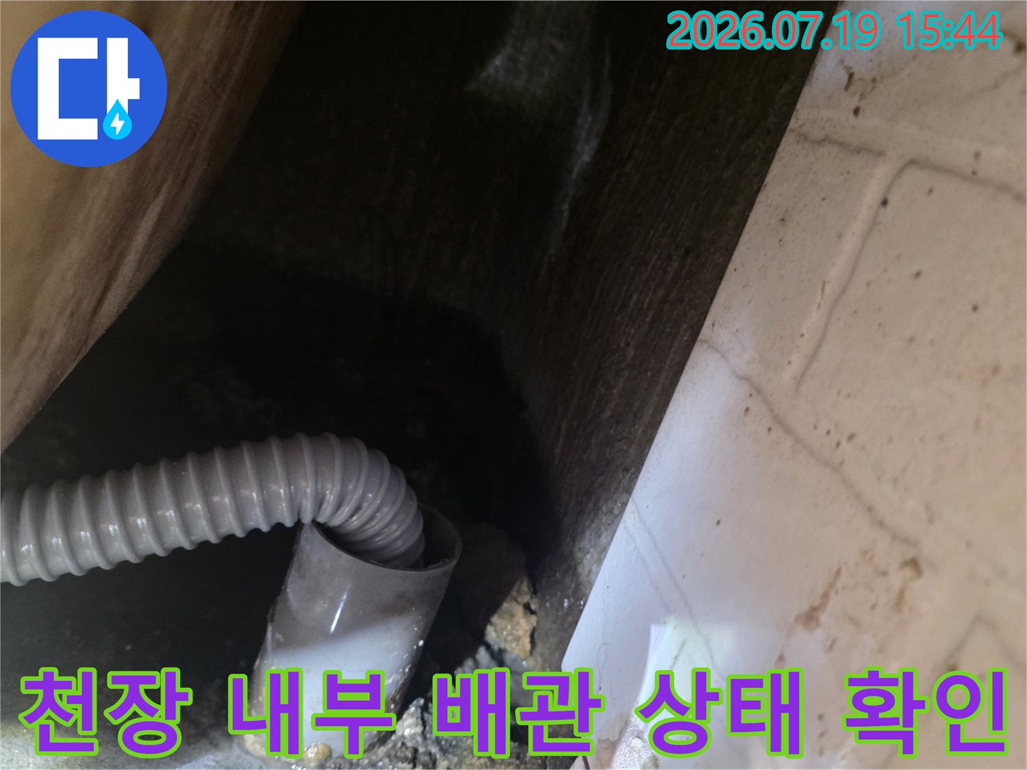 화장실 천장 안쪽의 주름관 형태 배관과 연결 부위를 촬영한 사진