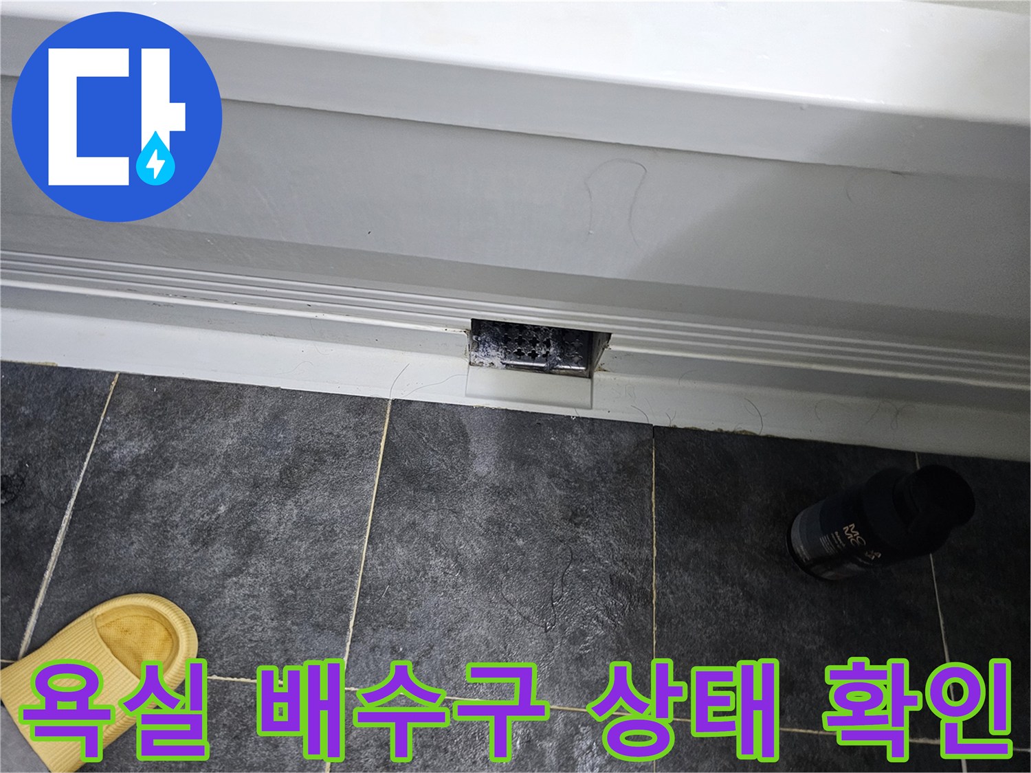어두운 회색 타일과 배수구 주변의 상태를 촬영한 사진입니다.