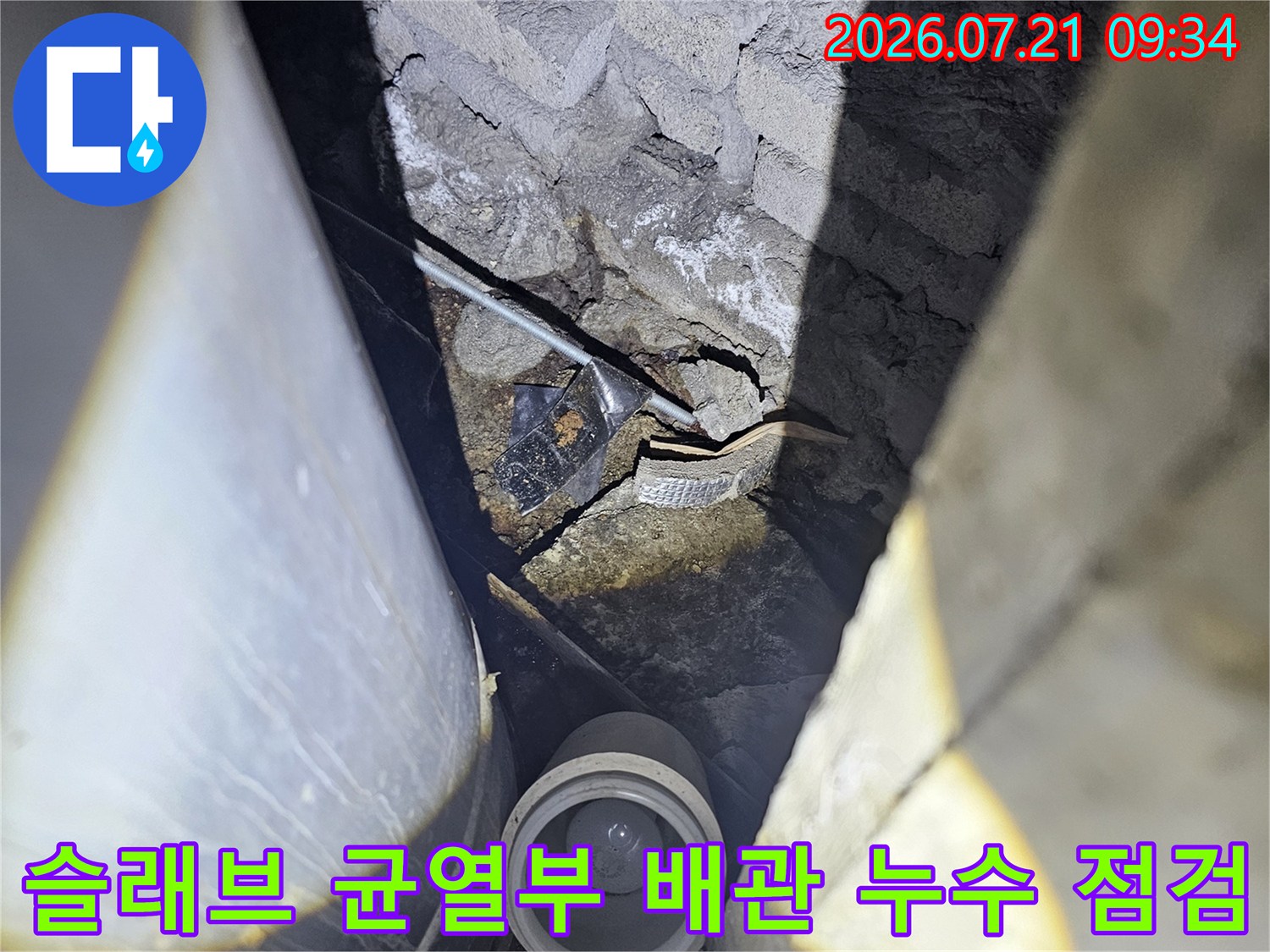 천장 슬래브 크랙과 노출된 배관 연결부를 정밀 진단하는 현장 사진