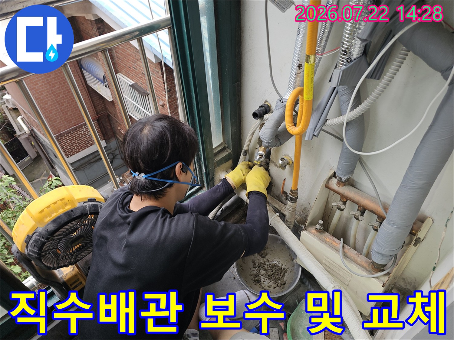 누수가 발생한 노란색 직수배관을 전문 기술자가 수리하는 모습