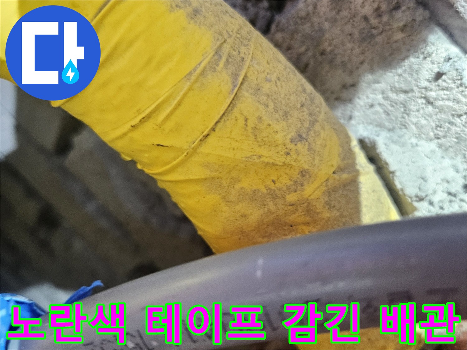 노란색 보온재가 씌워진 배관과 검은 호스의 연결 부위