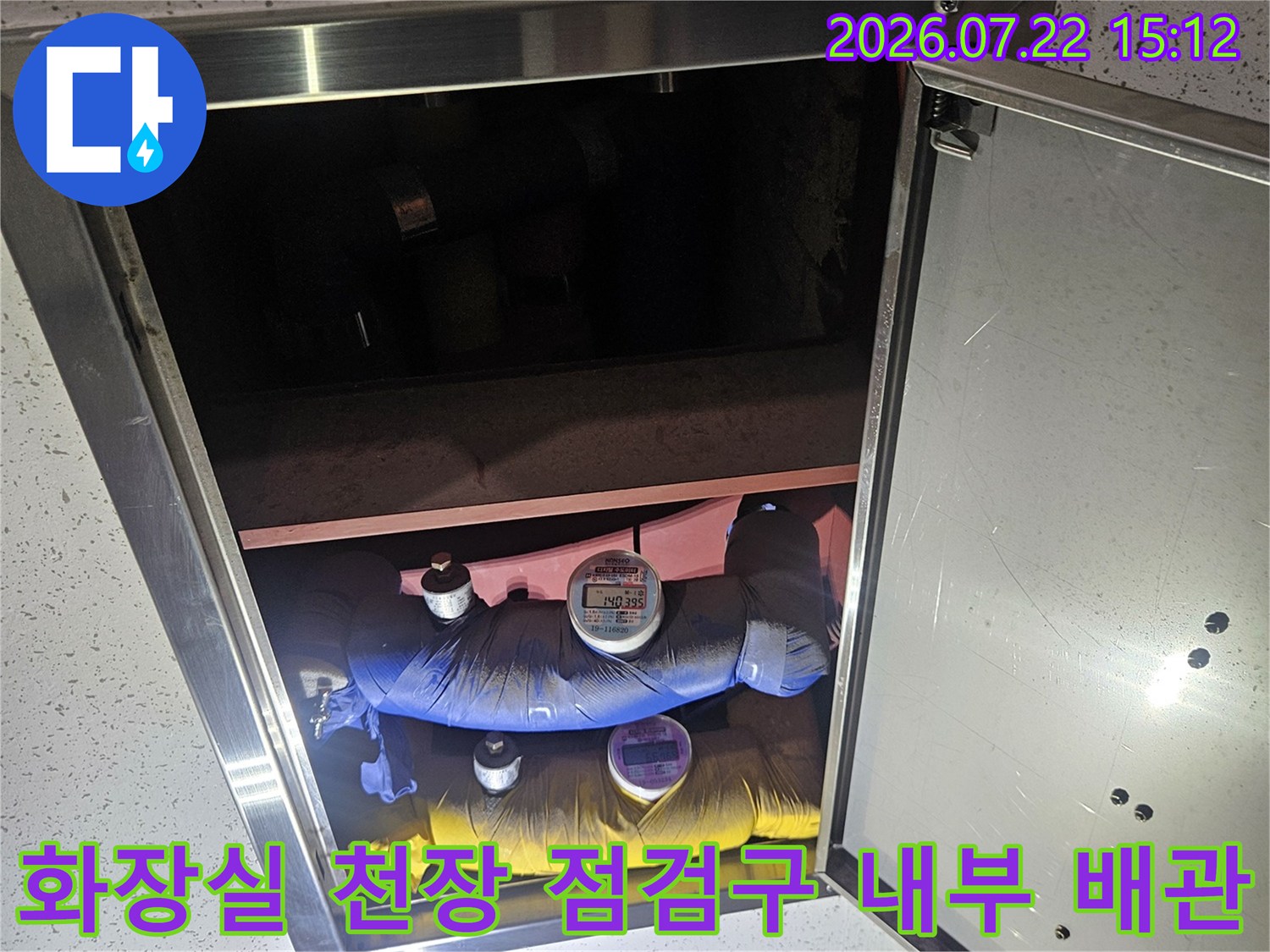 화장실-천장-점검구를-열어-내부에-설치된-파란색과-노란색-보온재-배관을-확인하는-모습