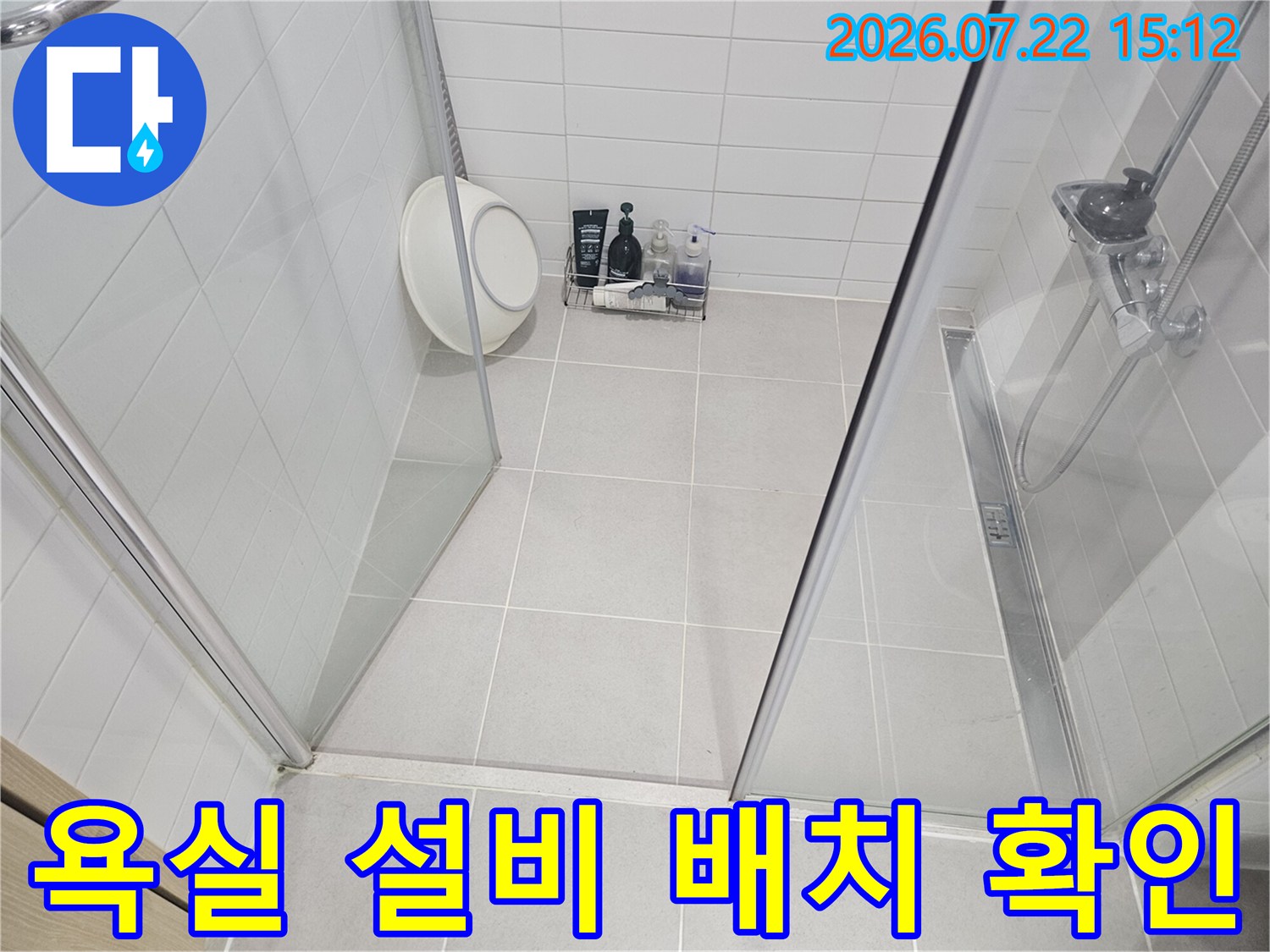 흰색 타일 마감의 욕실 내부-샤워 공간과 세면대 주변의 누수 가능성을 검토하는 사진
