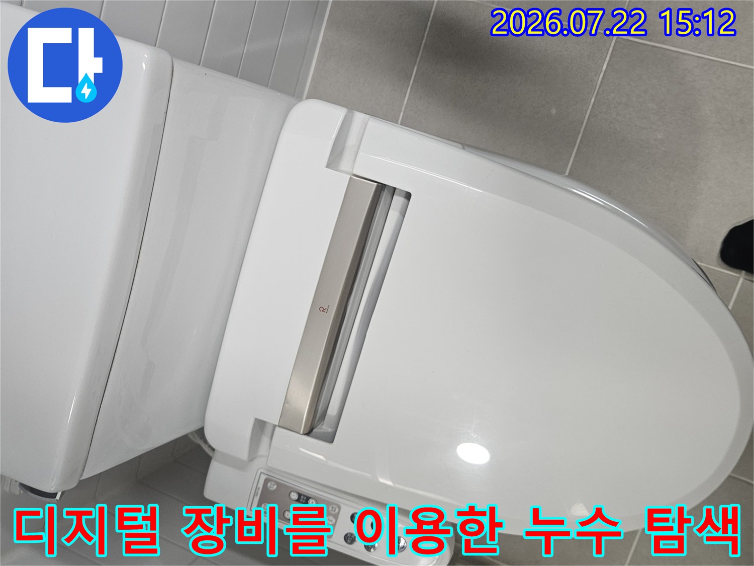 흰색 타일 화장실에서 변기 옆부분의 누수를 확인하기 위해 보쉬 측정기를 사용 중인 사진