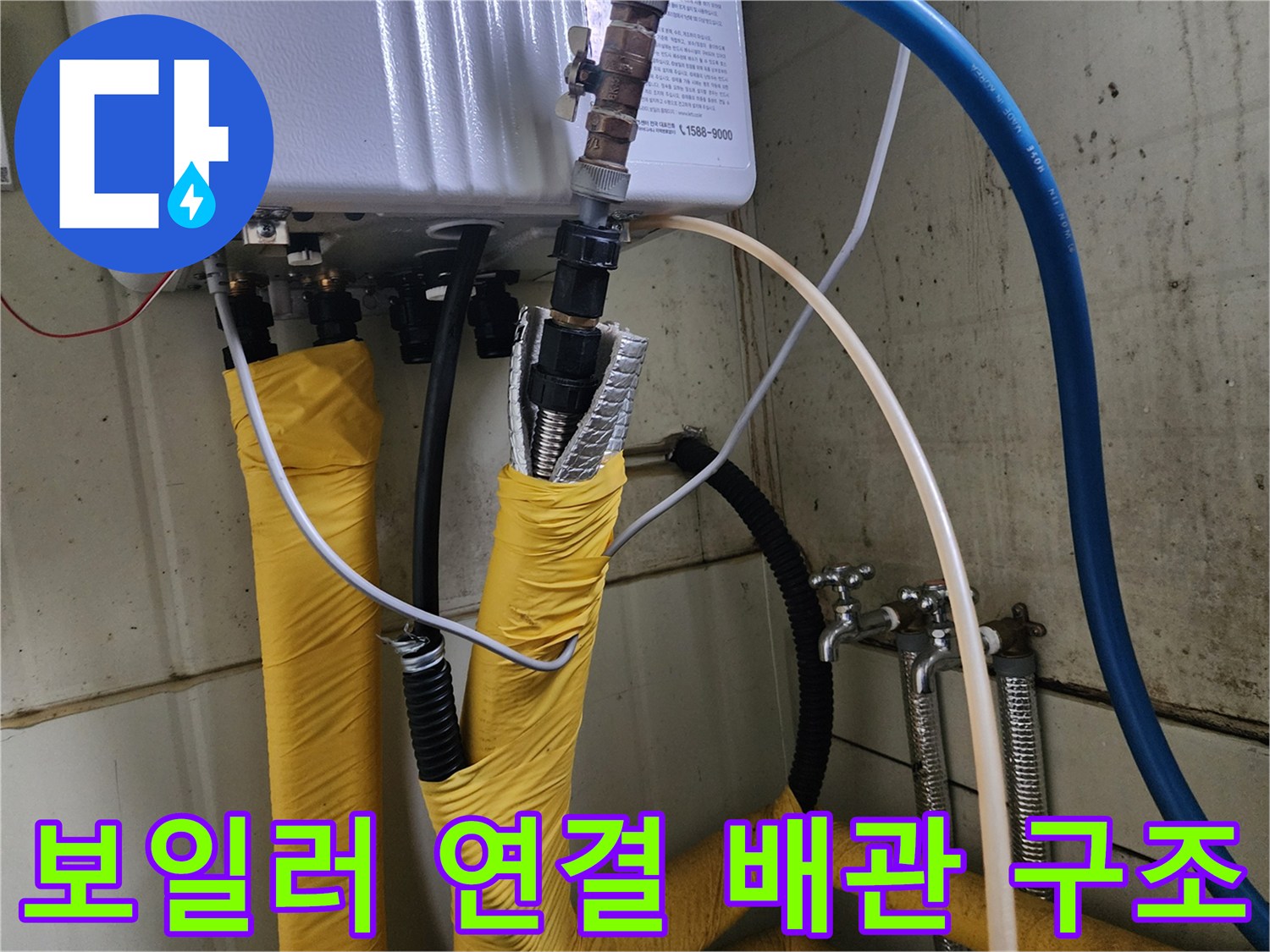 노란색 보온재와 파란색 호스가 연결된 보일러 하단부 모습
