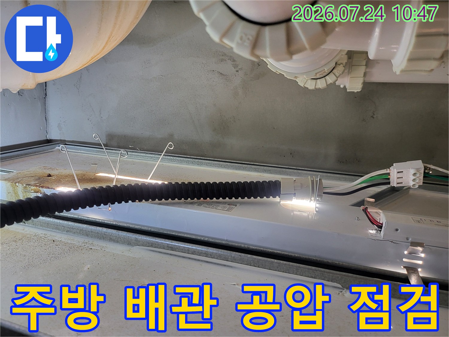 공압 테스트 장비를 활용하여 주방 싱크대 하부의 누수 여부를 정밀하게 진단하는 모습