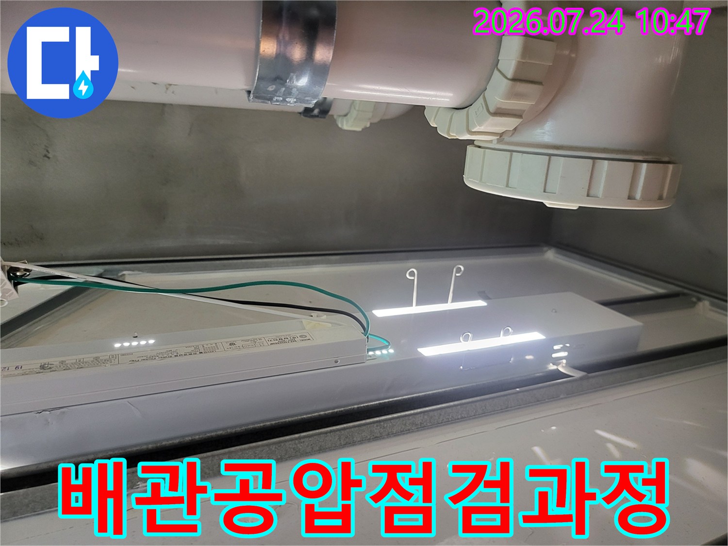 배관 공압 테스트 장비를 연결하고 천장 내부를 비추는 작업용 조명 설치 모습