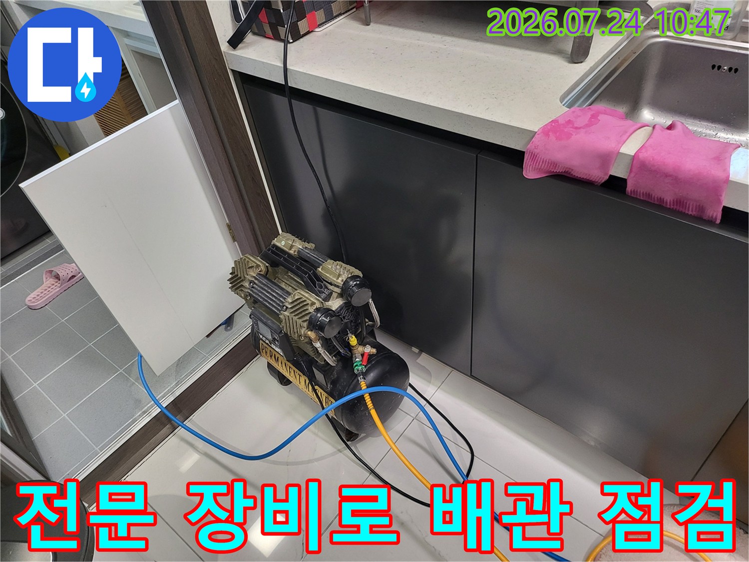 싱크대 하부 공간에서 다양한 색상의 호스를 사용하여 배관 압력을 테스트하는 과정