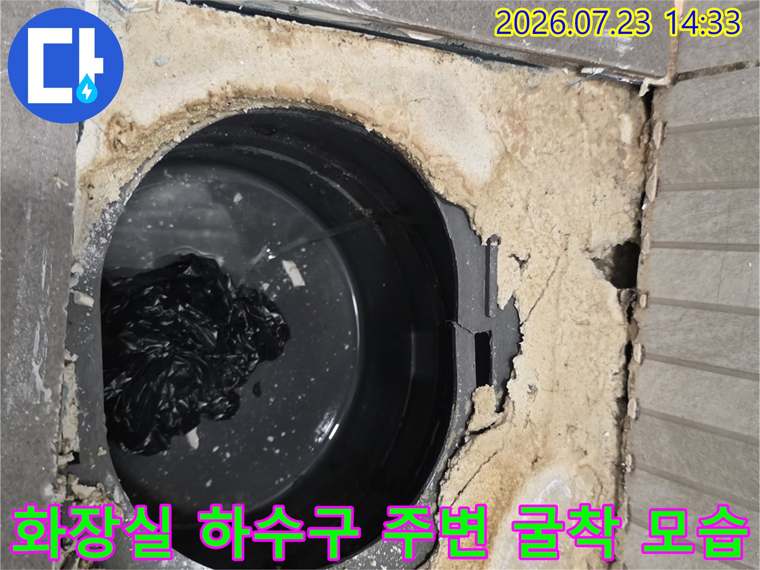 누수가-발생한-욕실-배수구-주변을-파내어-드러난-검정색-관과-손상된-시멘트-층
