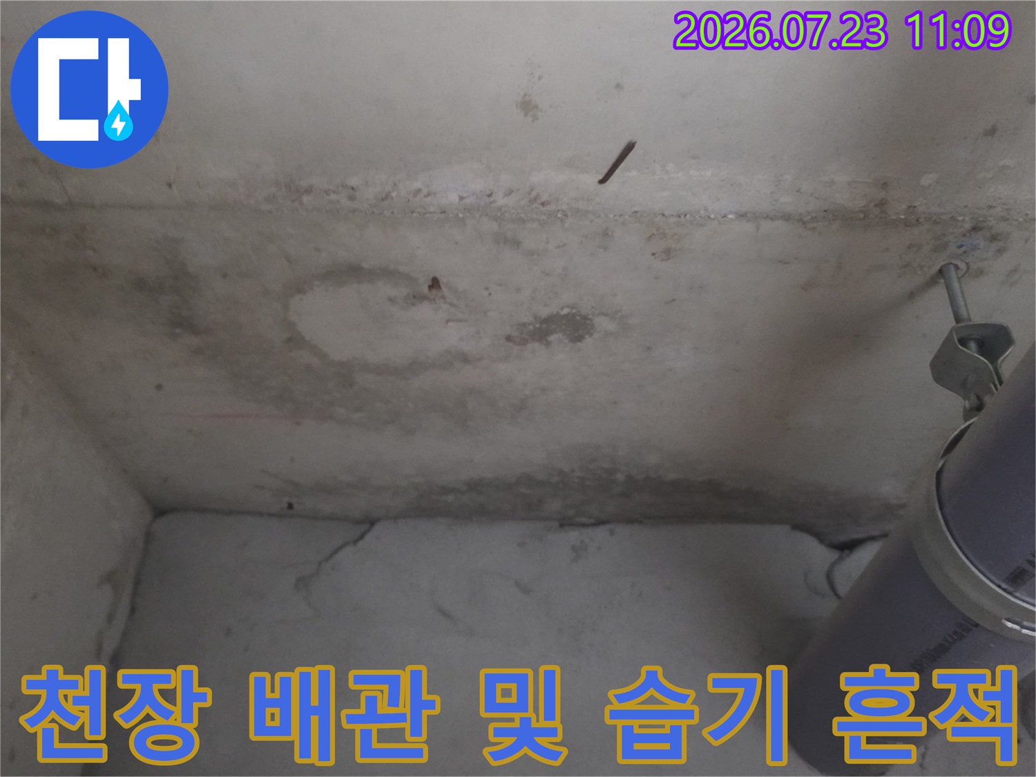 콘크리트 천장에 발생한 물 얼룩과 회색 배관 연결 부위-누수 진단 모습