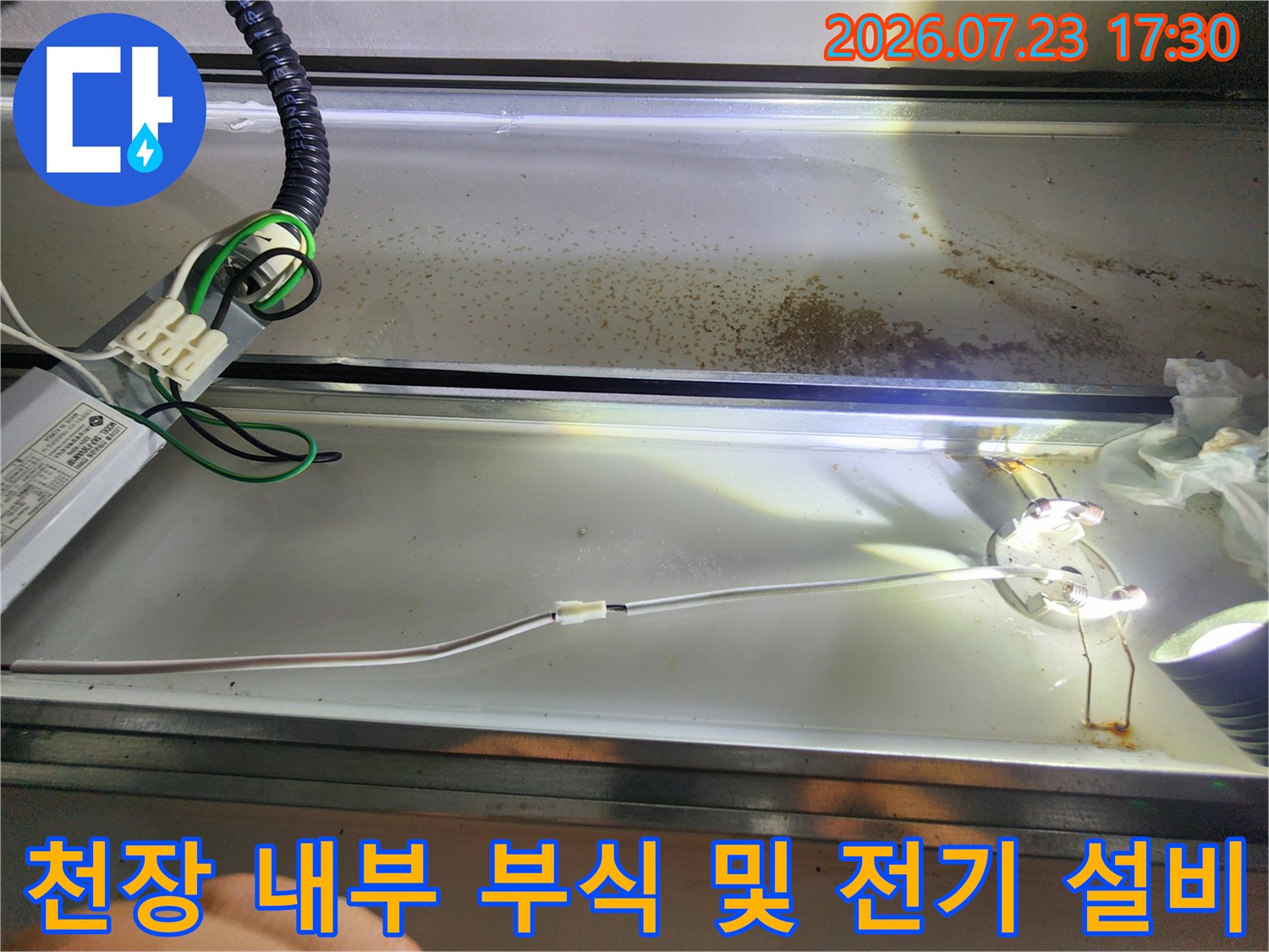 갈색으로-부식된-천장 금속판과-복잡하게 연결된-전기 배선 사진