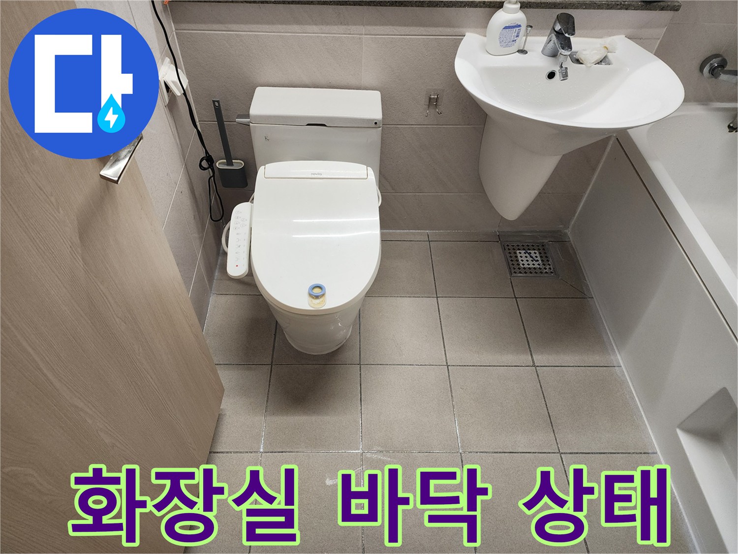 위례 화장실의 변기와 세면대 주변 타일 마감 상태를 보여주는 사진입니다.