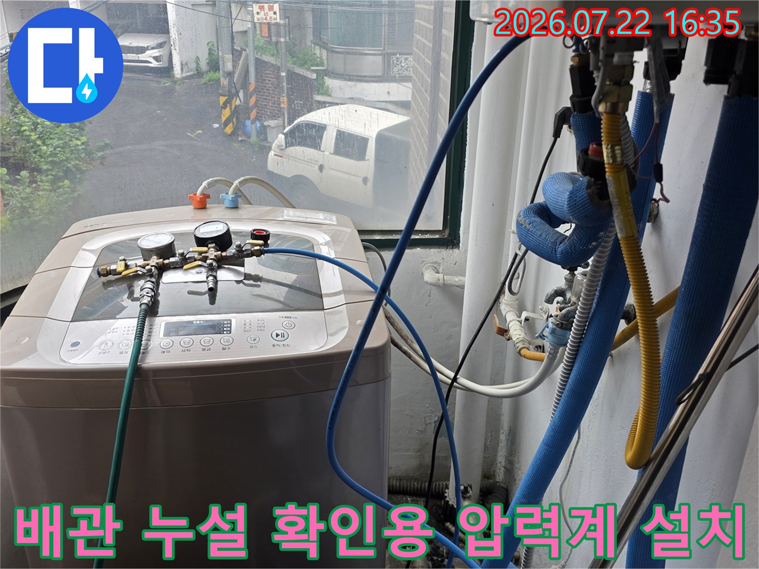 세탁기 위에 배치된 공압 테스트 장비와 배관 연결 부위의 상세 모습