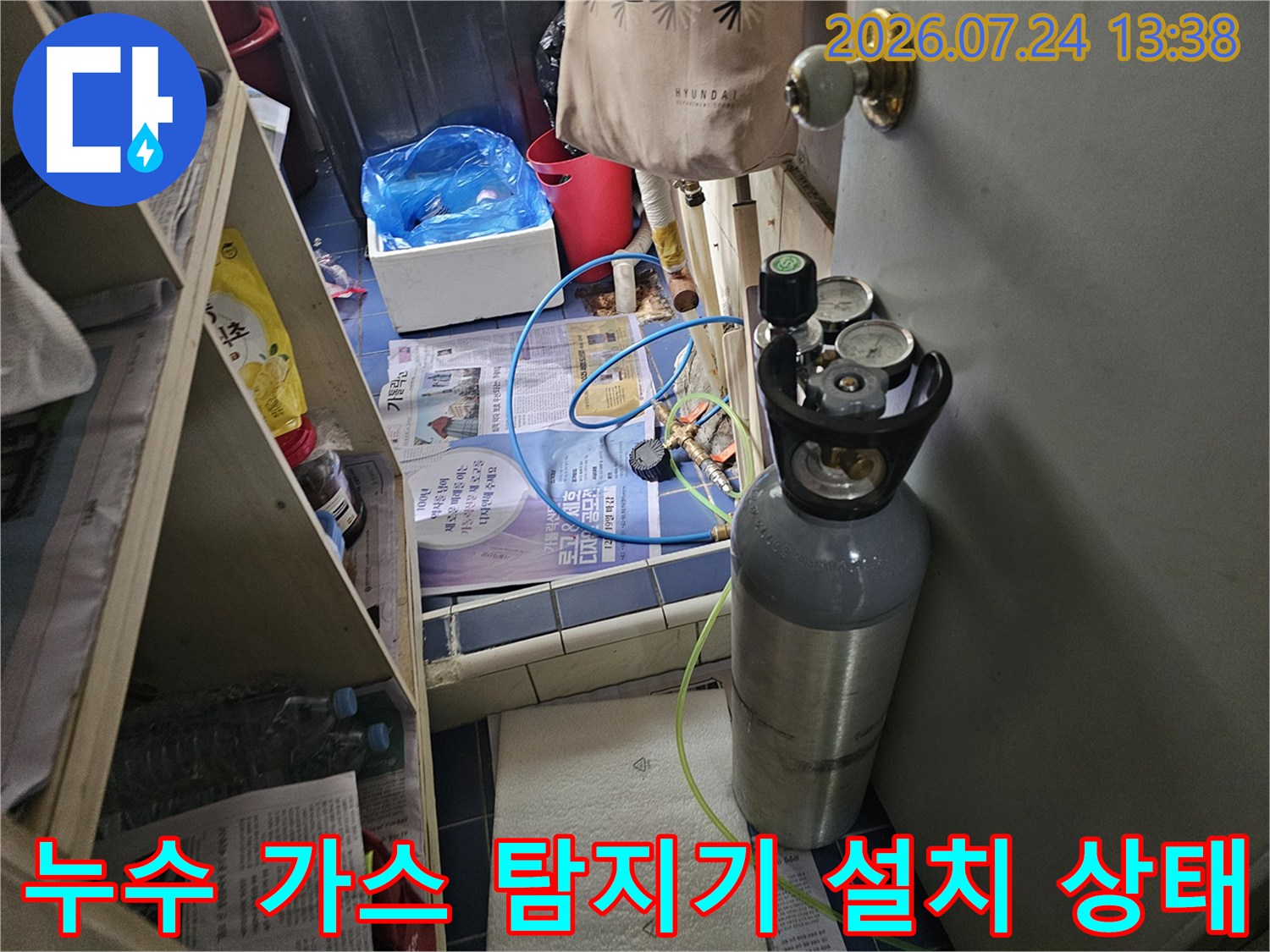 바닥에 놓인 회색 가스통과 압력 조절기가 연결된 누수 탐지 시스템-현장 사진