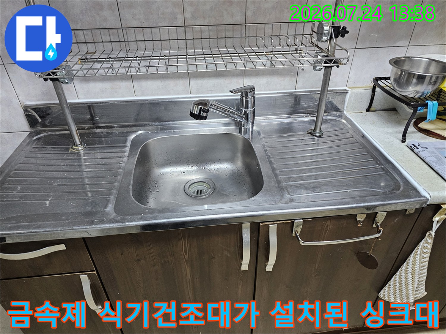 주방 싱크대 상단에 설치된 스텐 소재-식기건조대와 수전의 전체적인 모습