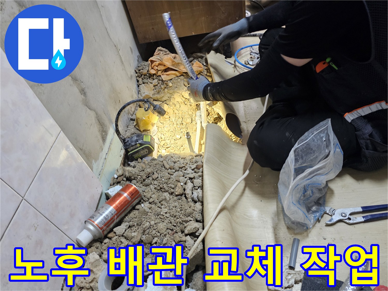 파손된 수도 배관을 새 부품으로 연결하고 있는 공사 현장 사진입니다.