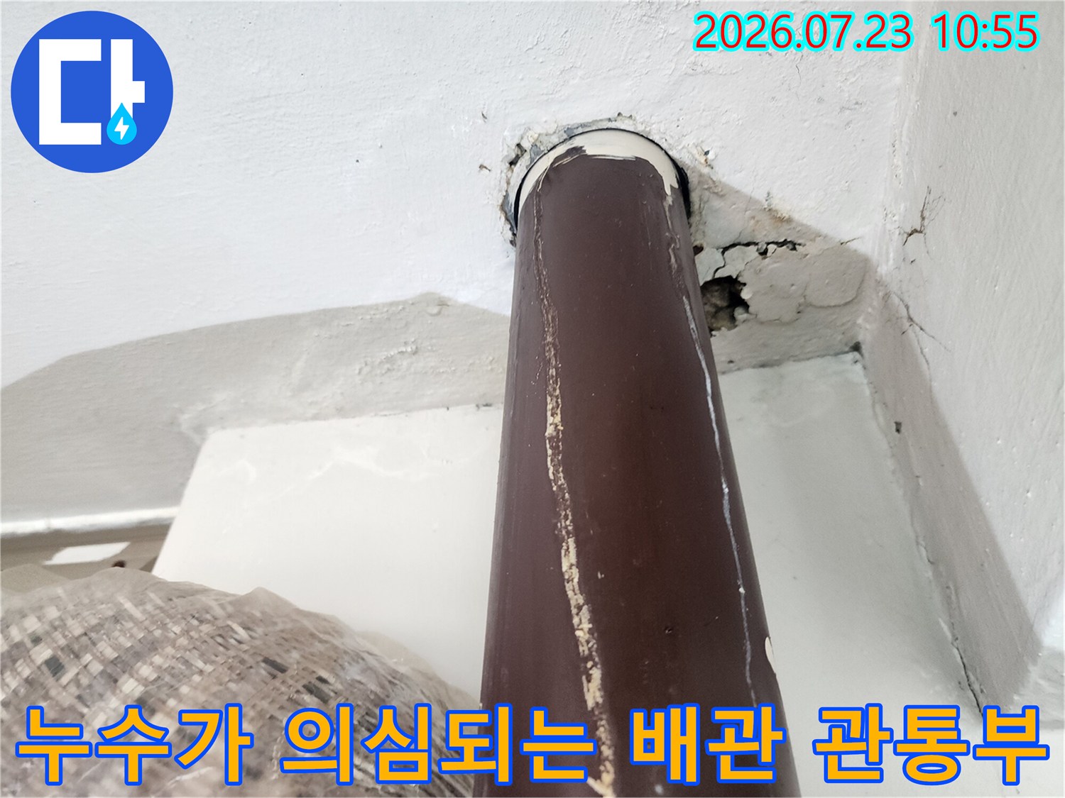 갈색 온수 파이프가 벽을 통과하는 지점-주변 마감재의 심한 균열과 틈새