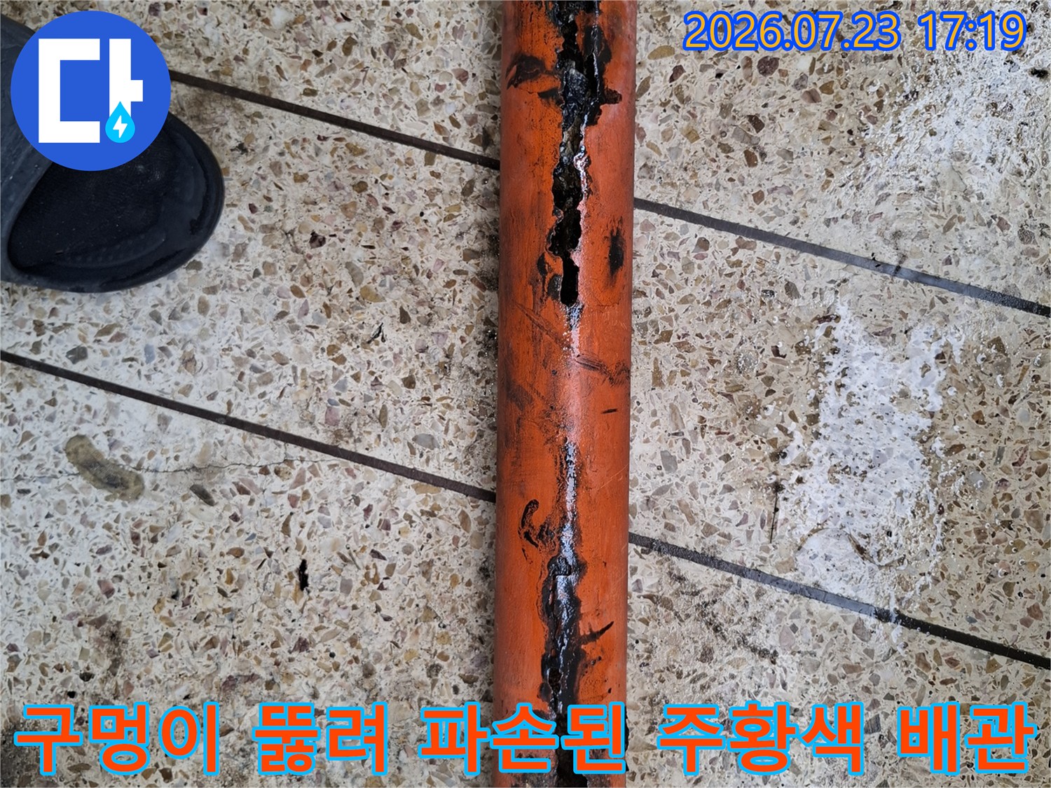 부식으로 인해 외벽이 함몰되고 구멍이 난 오렌지색 누수 배관-제거 전 모습
