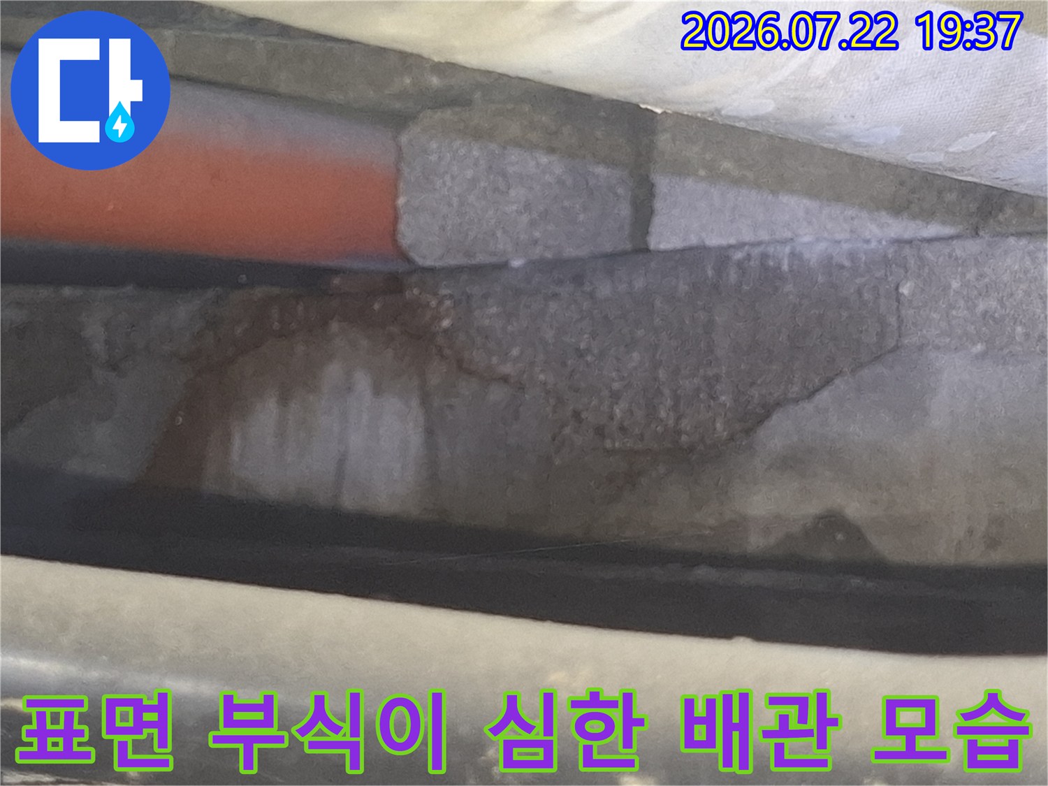 천장-부식으로 인해 표면이 울퉁불퉁하게 변한 오렌지색 배관의 근접 사진