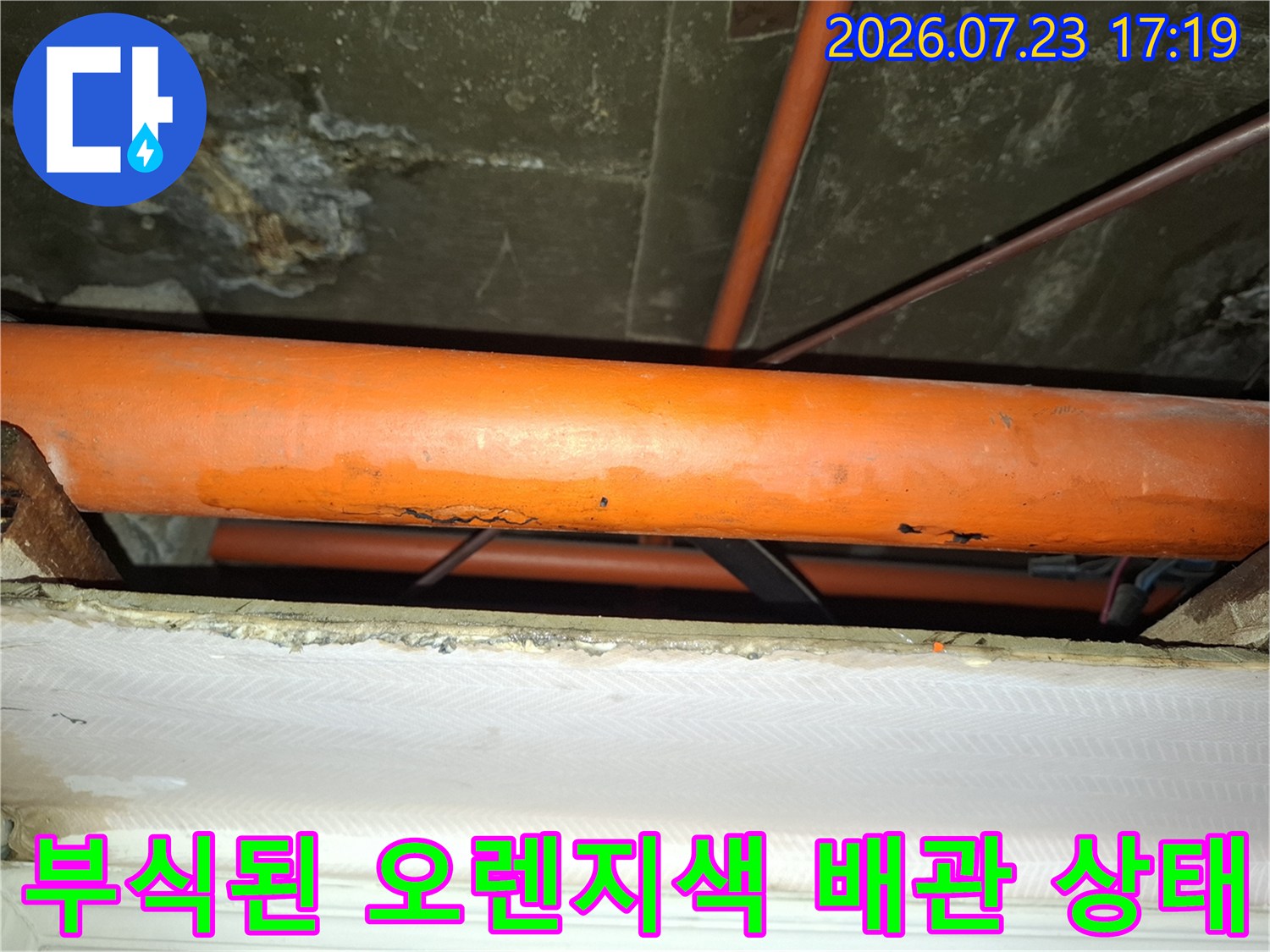천장에 설치된-오렌지색-플라스틱-배관의-표면이-부식되어-거칠어진-모습
