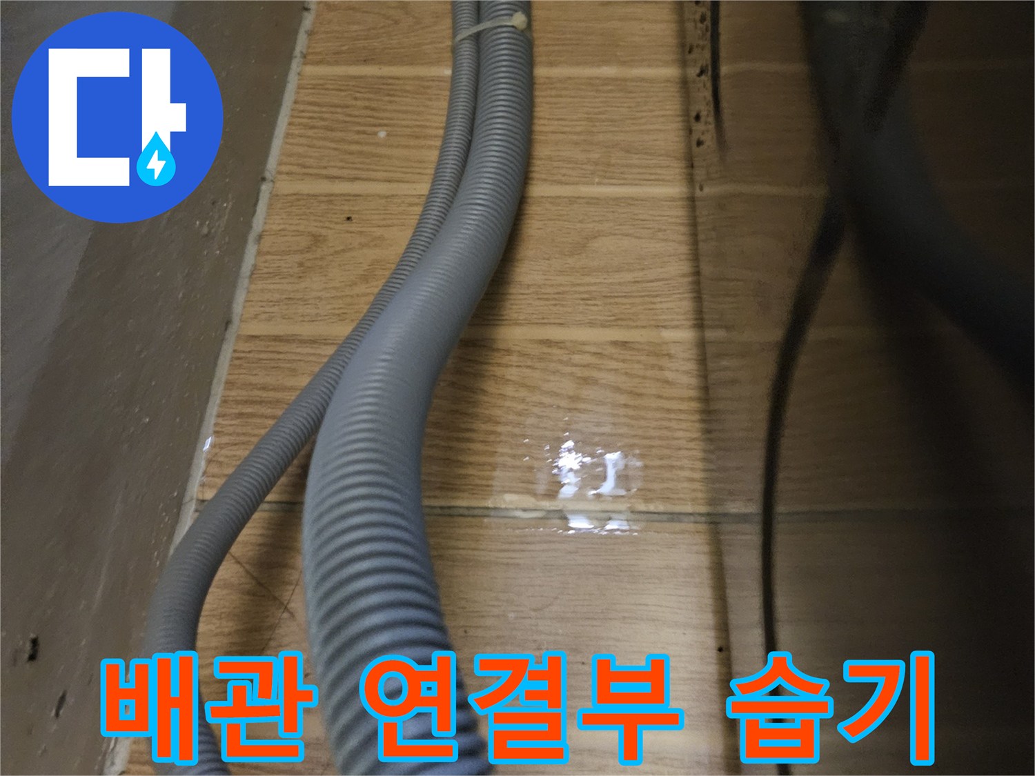 싱크대 배수 호스 주변의 젖은 타일 표면 상세 촬영