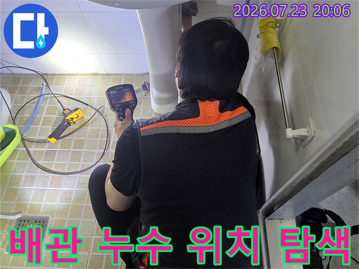 작업자가 세면대 하단부의 배관 연결 부위를 전문 장비로 꼼꼼하게 점검하는 현장 사진