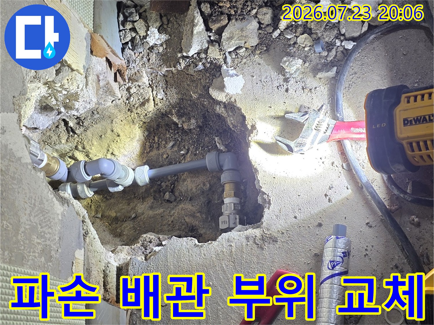 파손된 수도 배관 연결부를 노출하여 새 자재로 보강하는 현장 사진