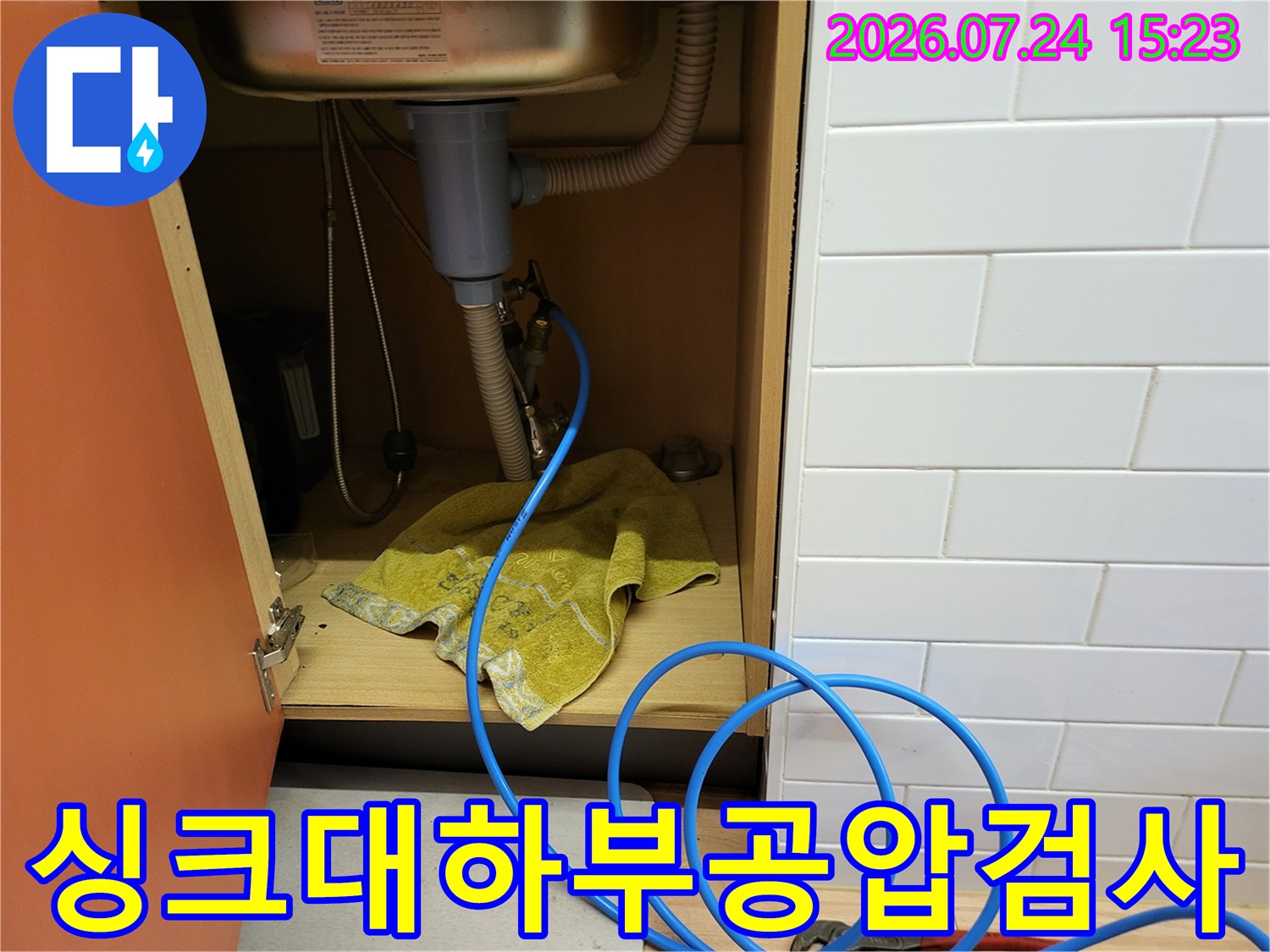 싱크대-하부-배관에-파란색-공압-테스트-호스가-연결된-모습