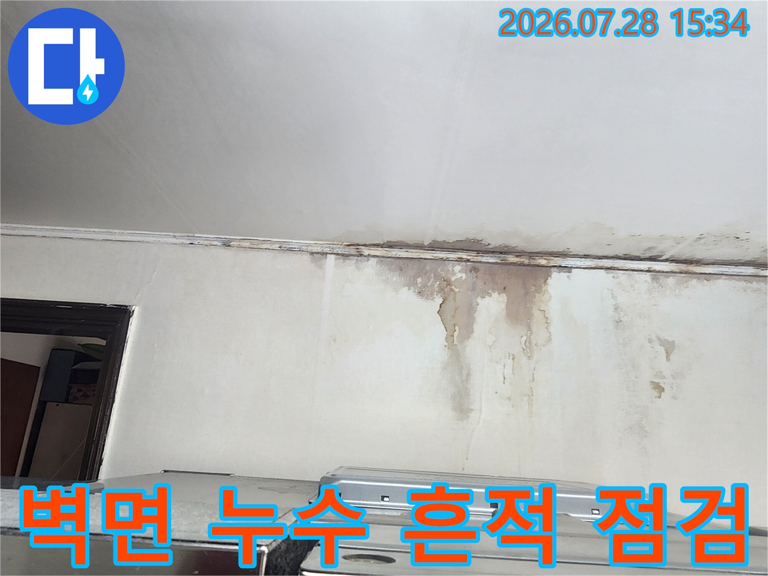 벽과 천장이 만나는 지점에 발생한 물샘으로 인한 변색과 오염 상태