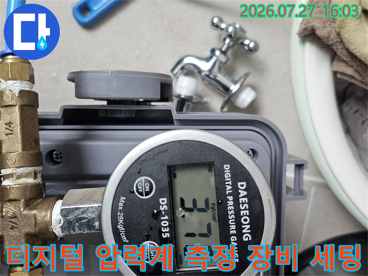 누수 탐지용 디지털 게이지가 파란색 호스와 밸브에 연결되어 작동 중인 모습