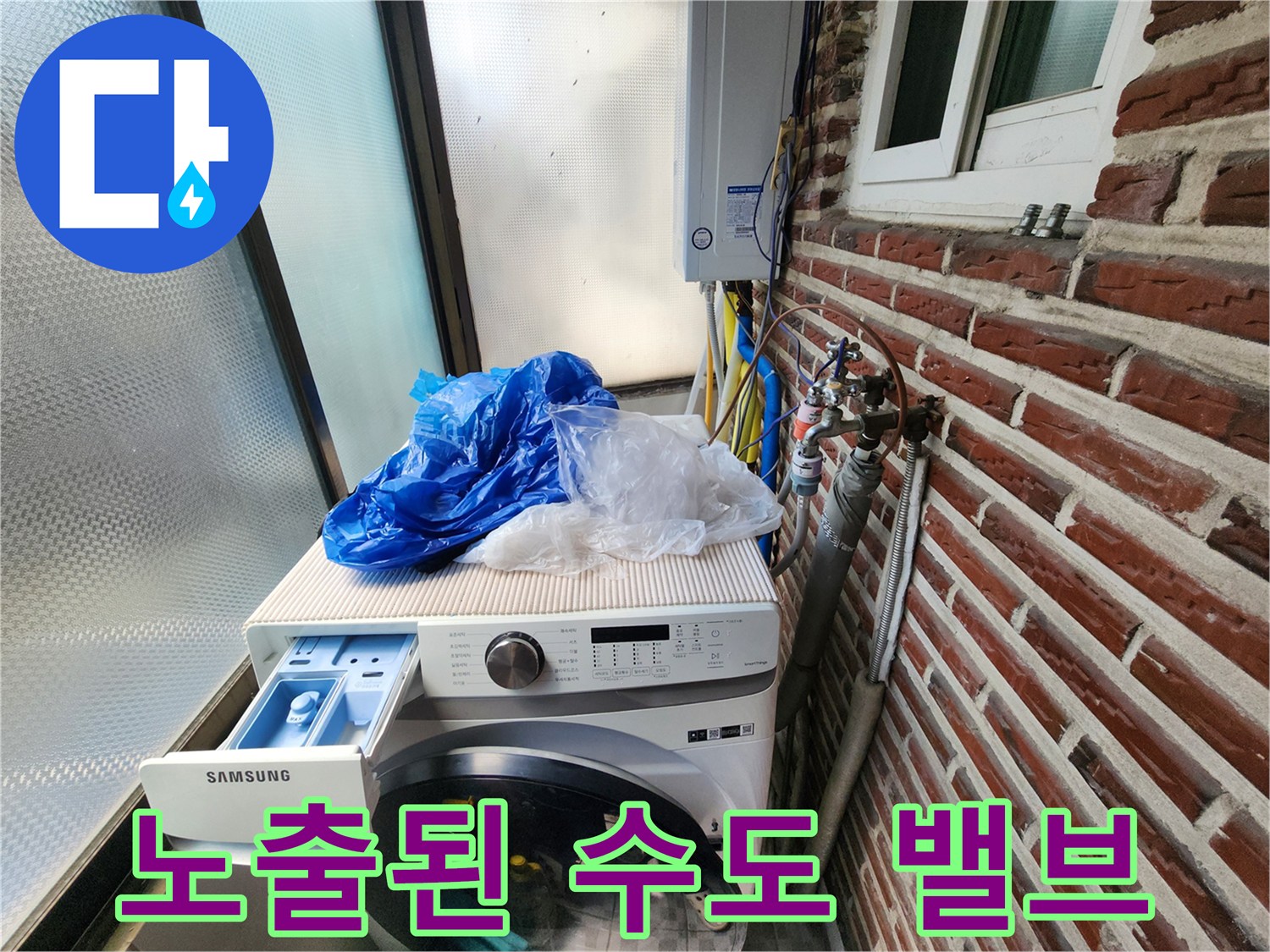 붉은 벽돌 외벽에 연결된 수도 밸브와 배관의 노출 상태