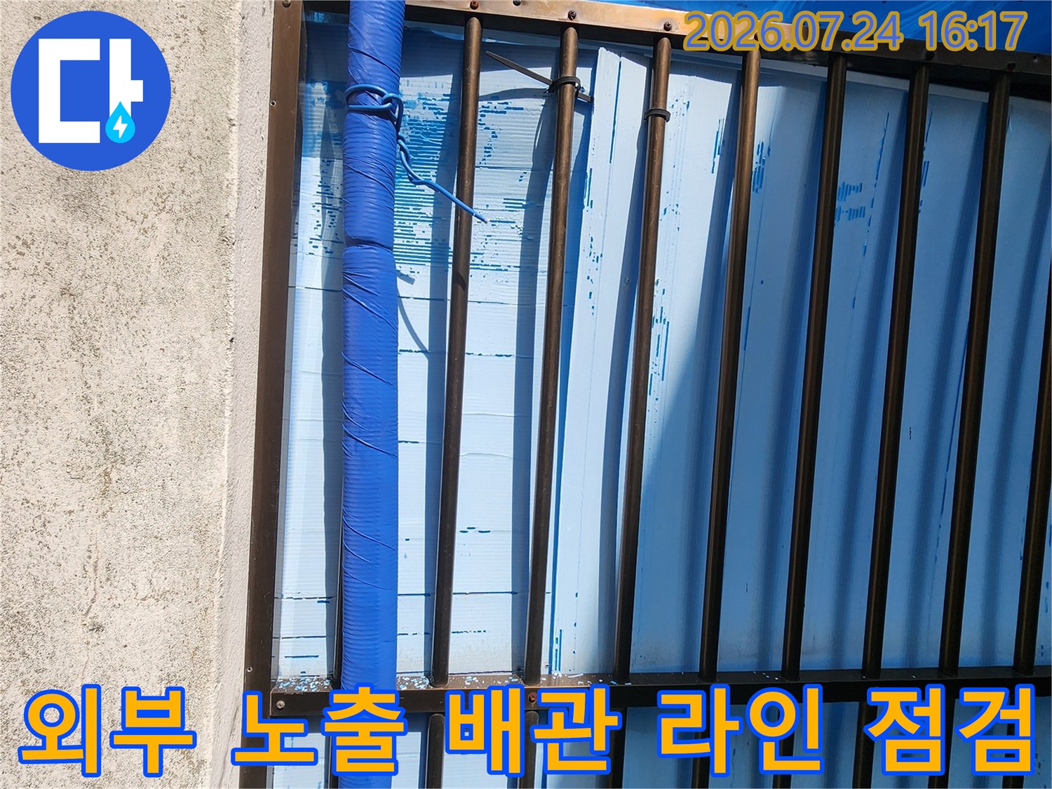 성북구 상가 건물 외벽을 따라 설치된 파란색 보온재 배관의 모습