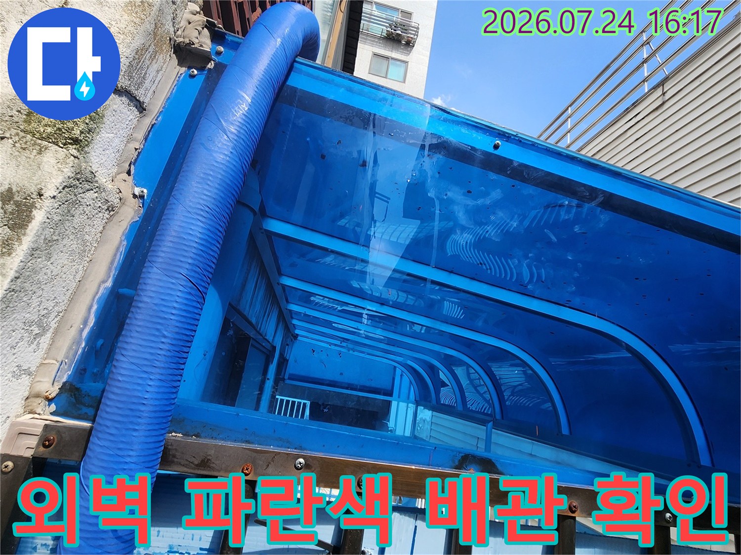파란색 보온재로 마감된 외벽 노출 수도 배관 시스템
