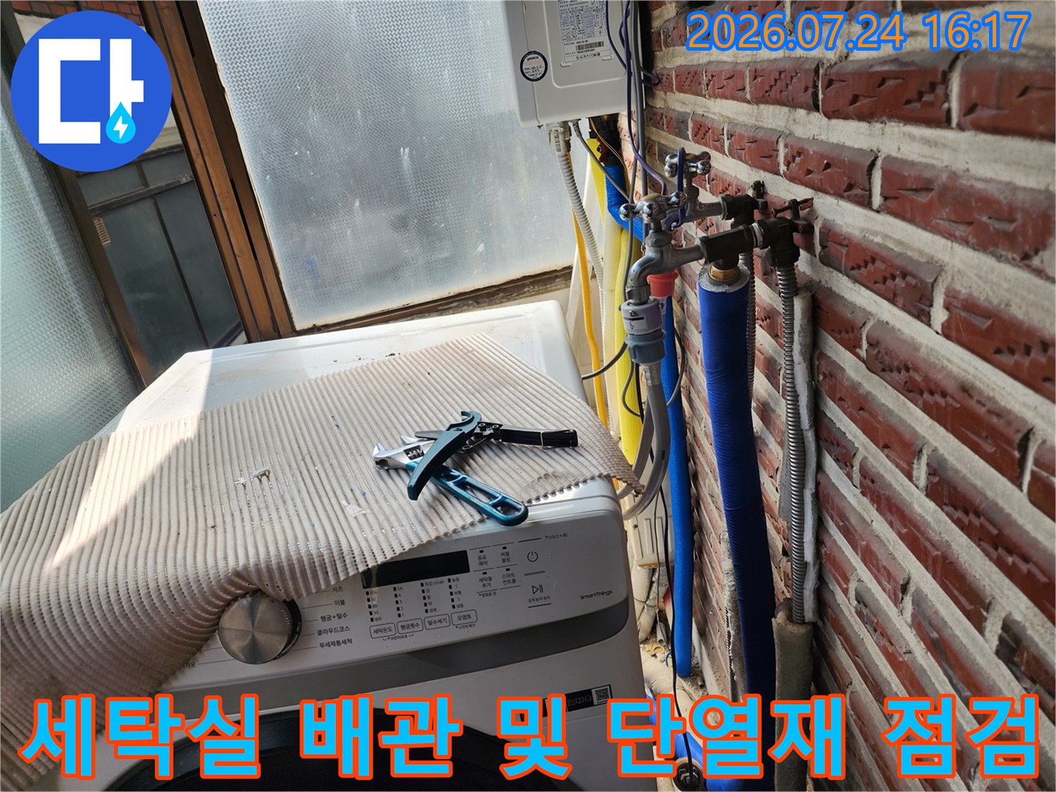 파란색 보온재와 은색 마감재로 감싸진 수도 배관의 노출 구간 점검