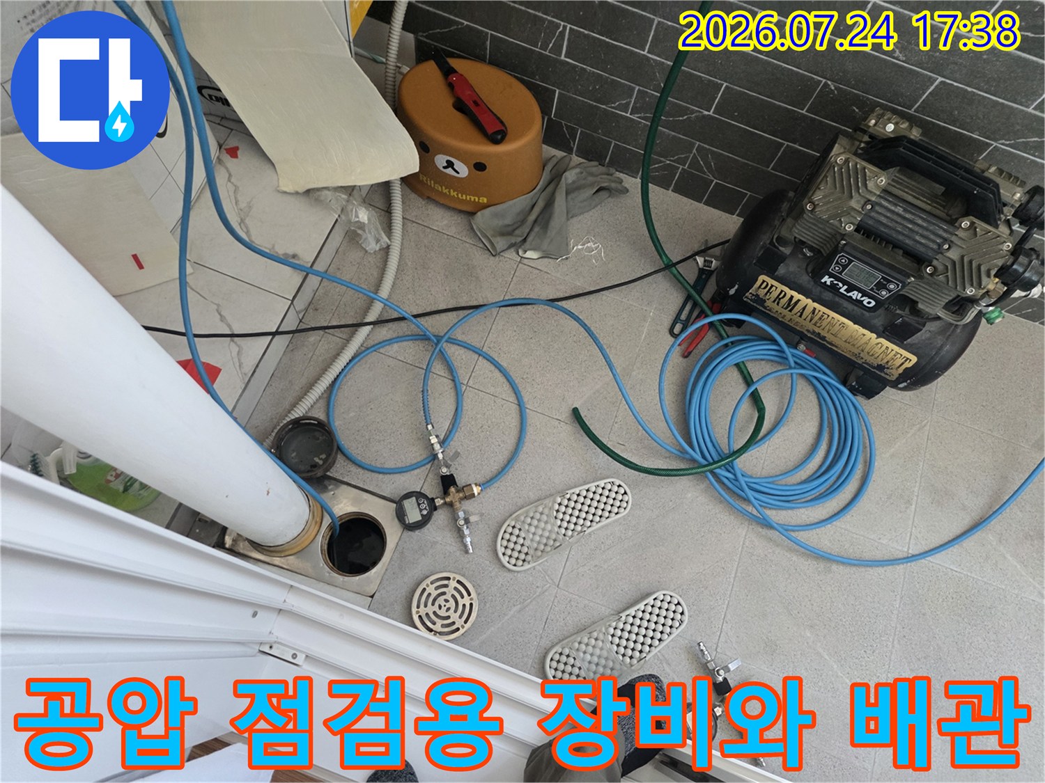 공압 검사기를 연결한 파란색 호스와 분배기 밸브를 점검하는 모습