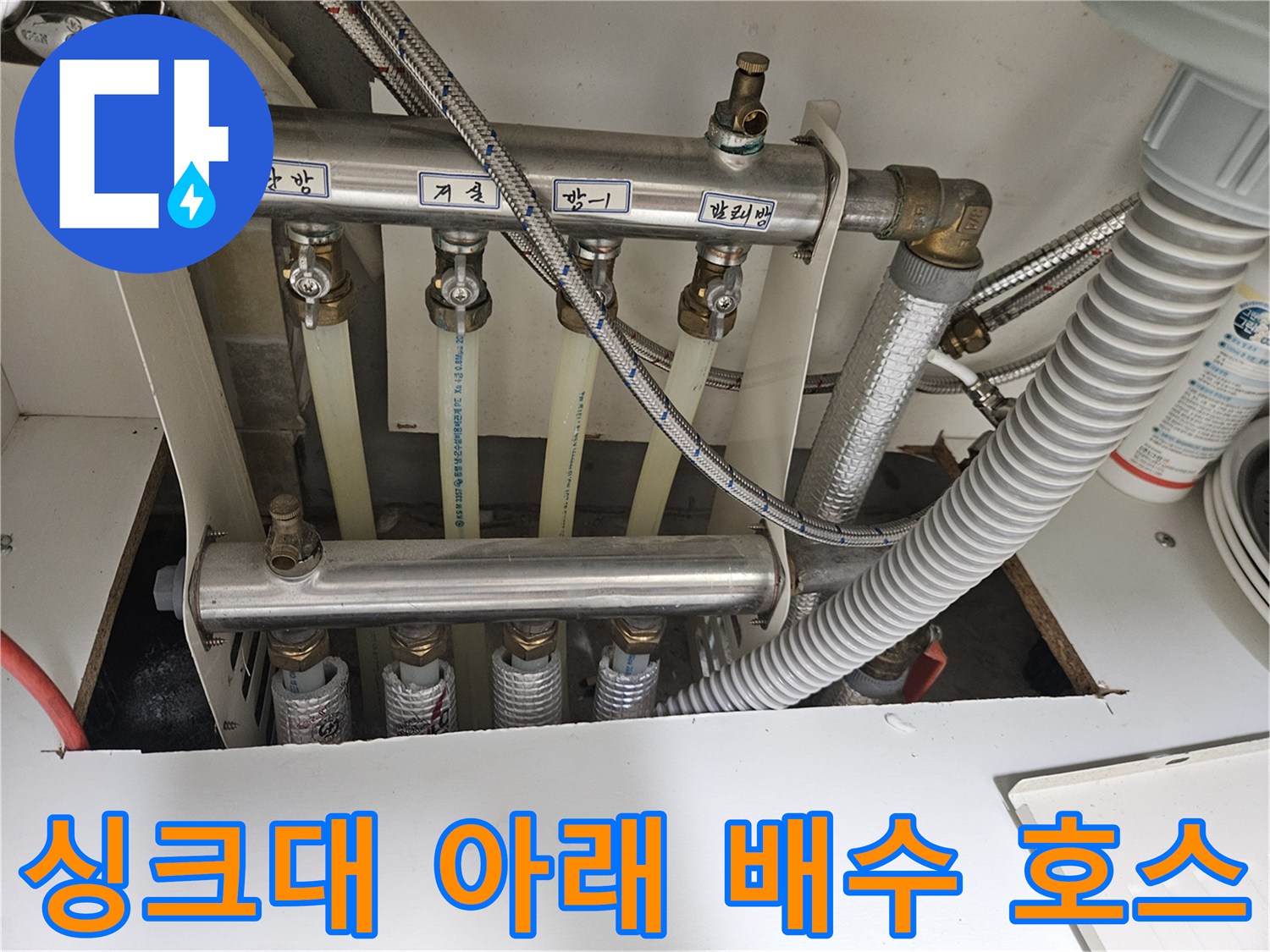싱크대 하부의 금속 배관과 유연한 호스 연결 구간